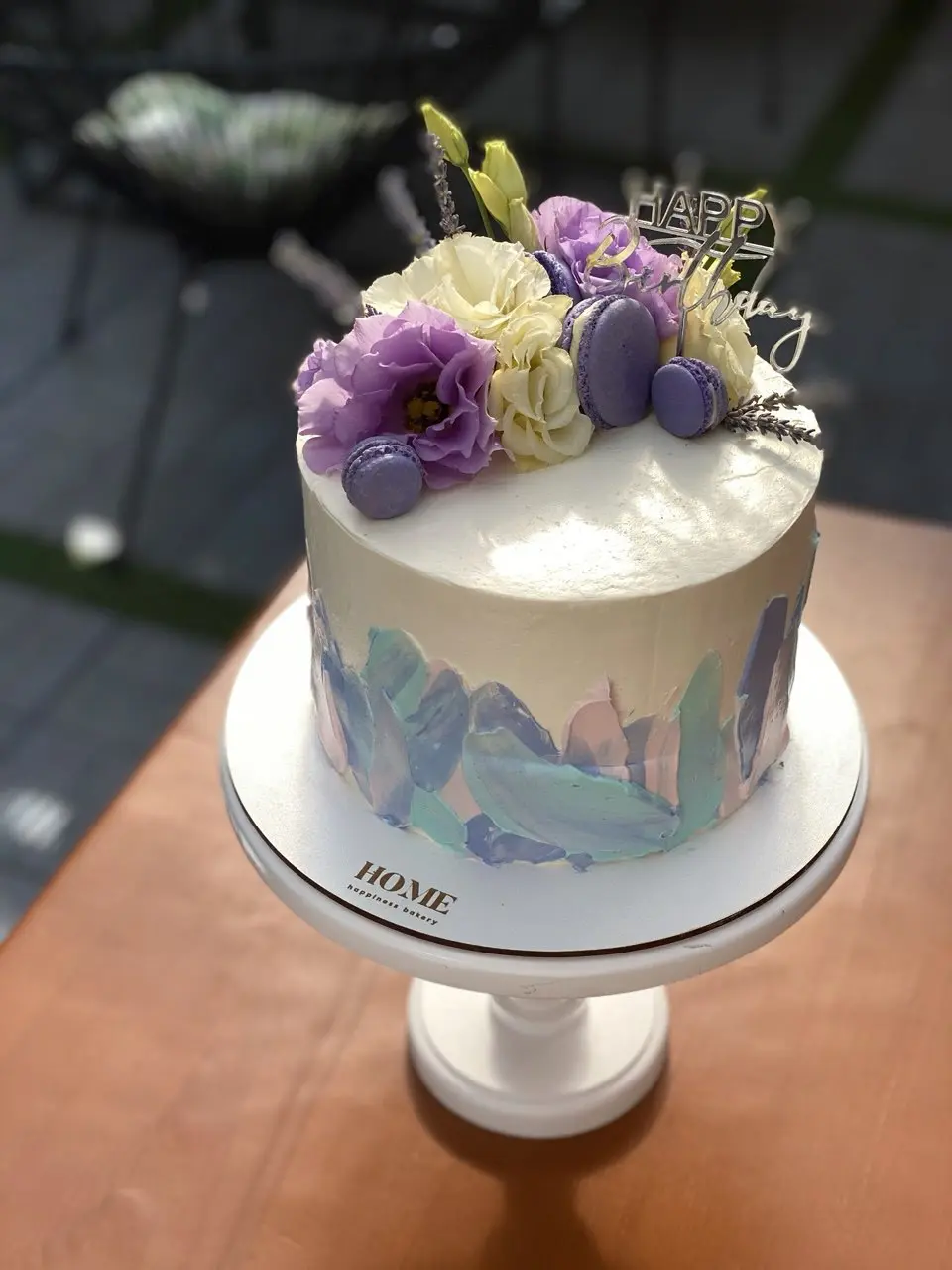White cake with purple flowers and watercolor brush stroke design