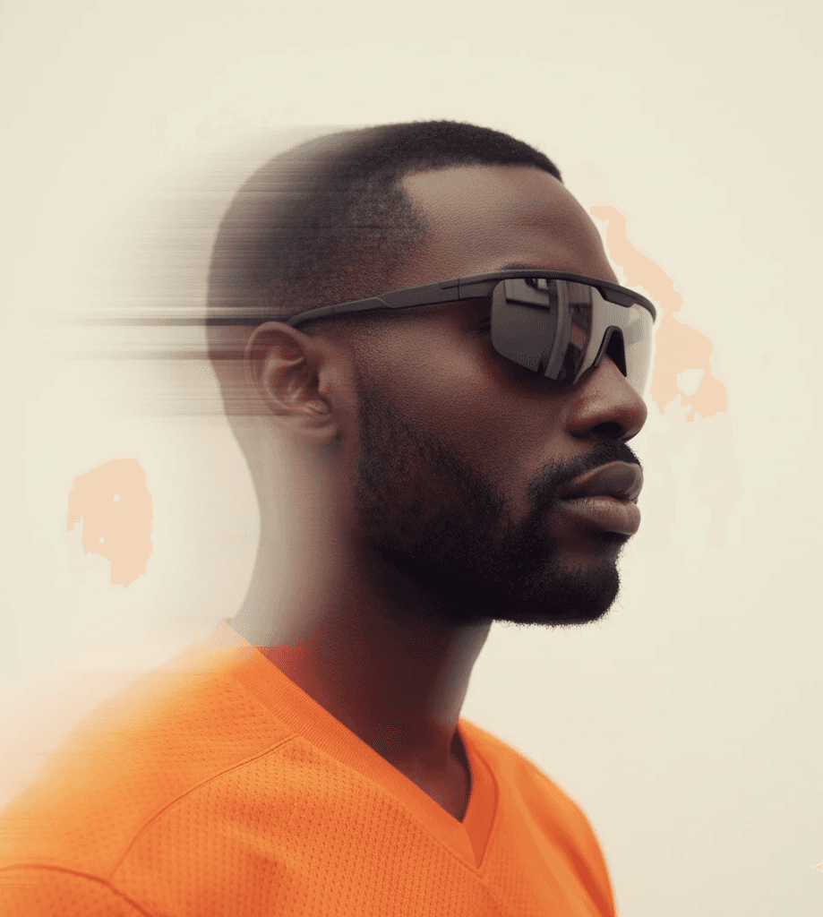 Side profile of Black man in orange shirt with motion-blur sunglasses effect.