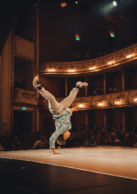 Akrobata w tearze w trakcie wykonywania dynamicznej ewolucji stojący na jednej ręce