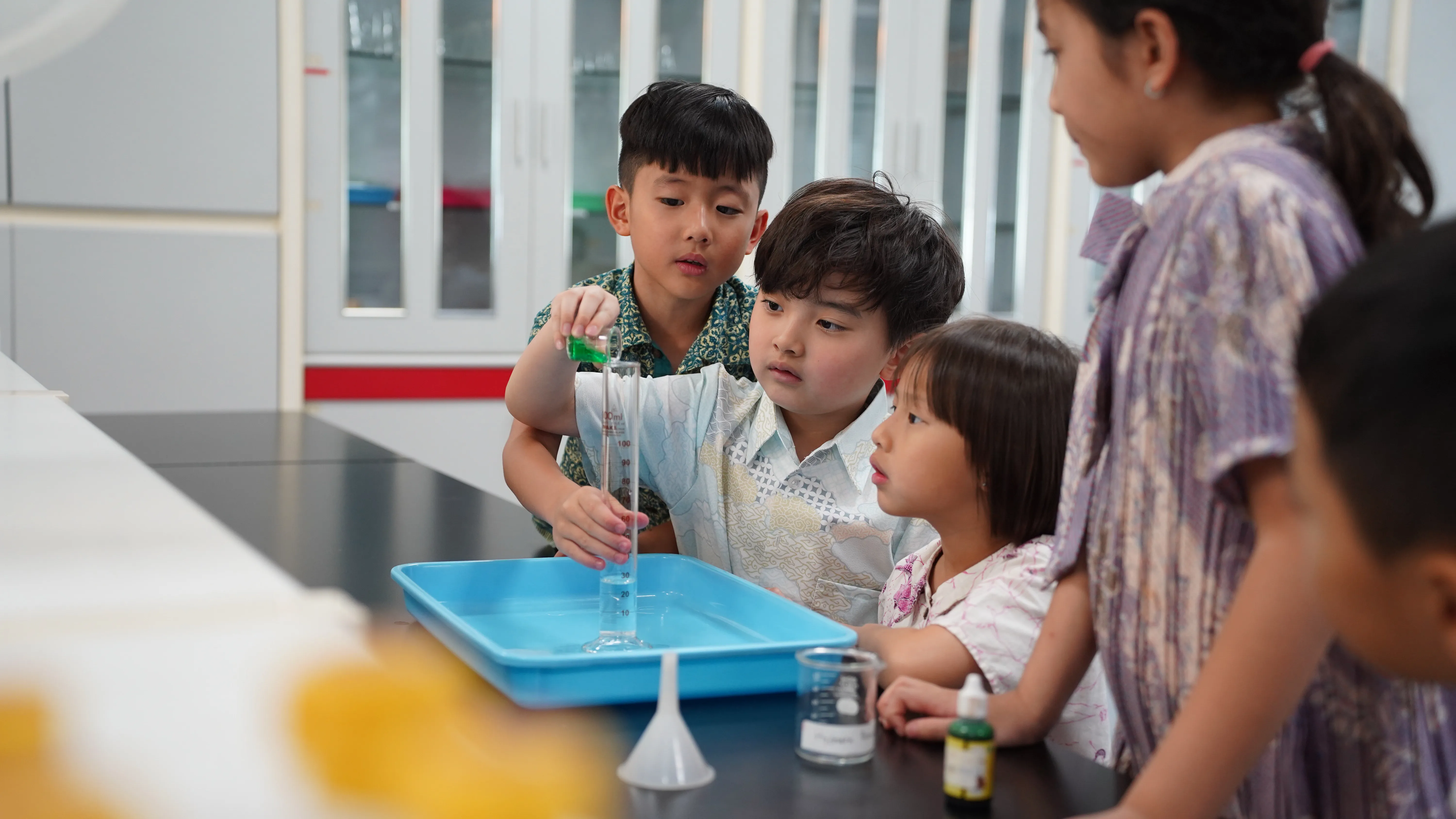 person writing on brown wooden table near white ceramic mug