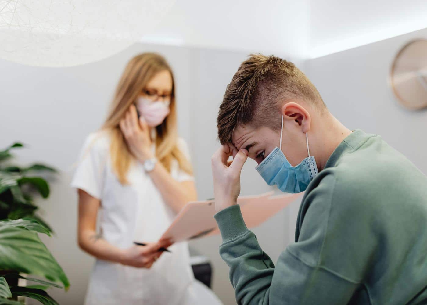 Anxious man with facemask on with woman doctor