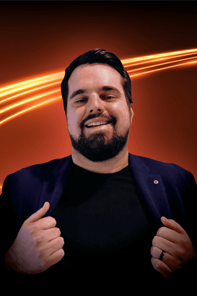 Young man with dark curly hair and beard, smiling.