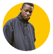A Black man wearing a navy blue jacket is featured in a yellow circle.