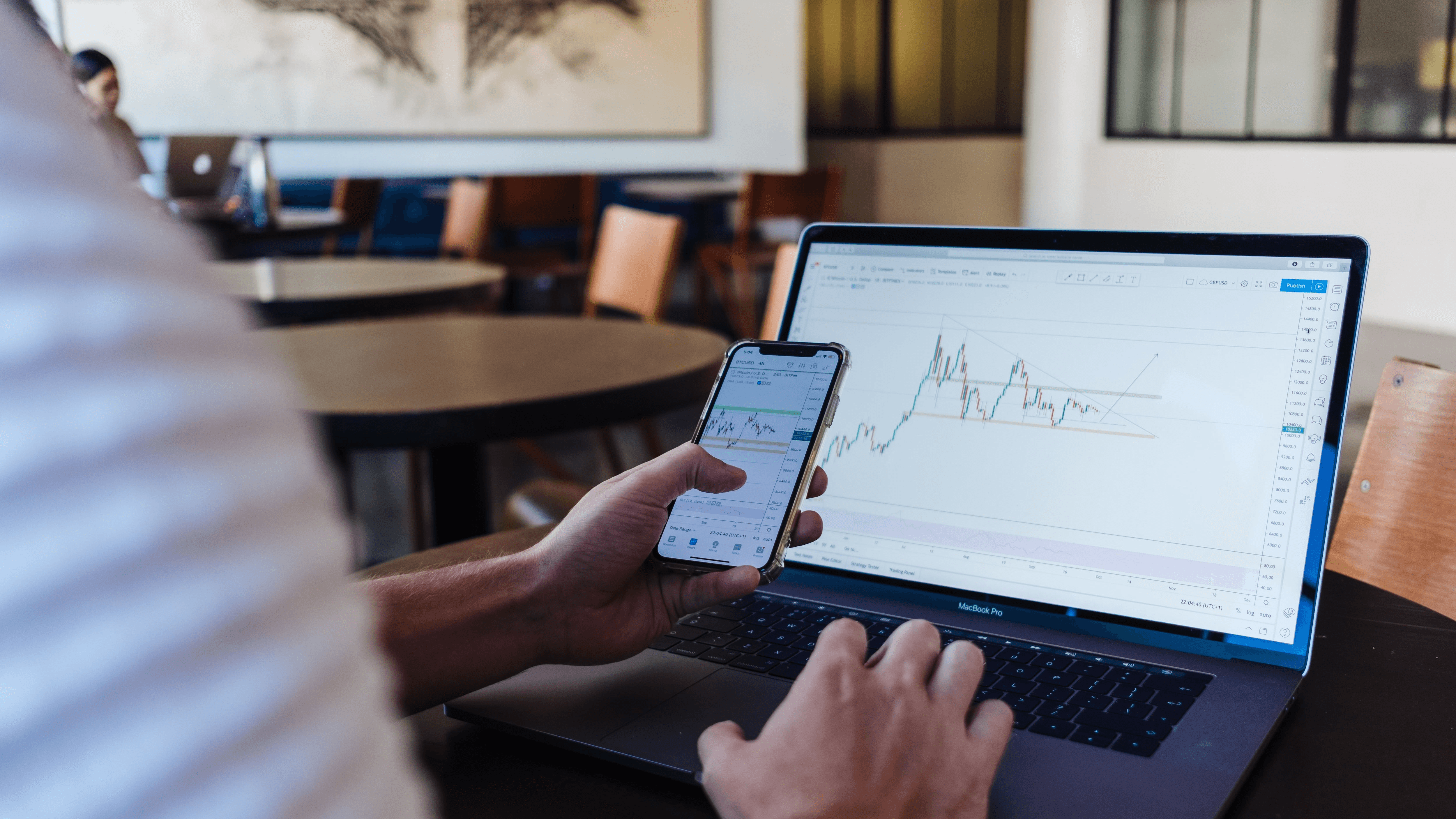  Person analyzing stock charts on devices - What Does Onchain Mean in Crypto