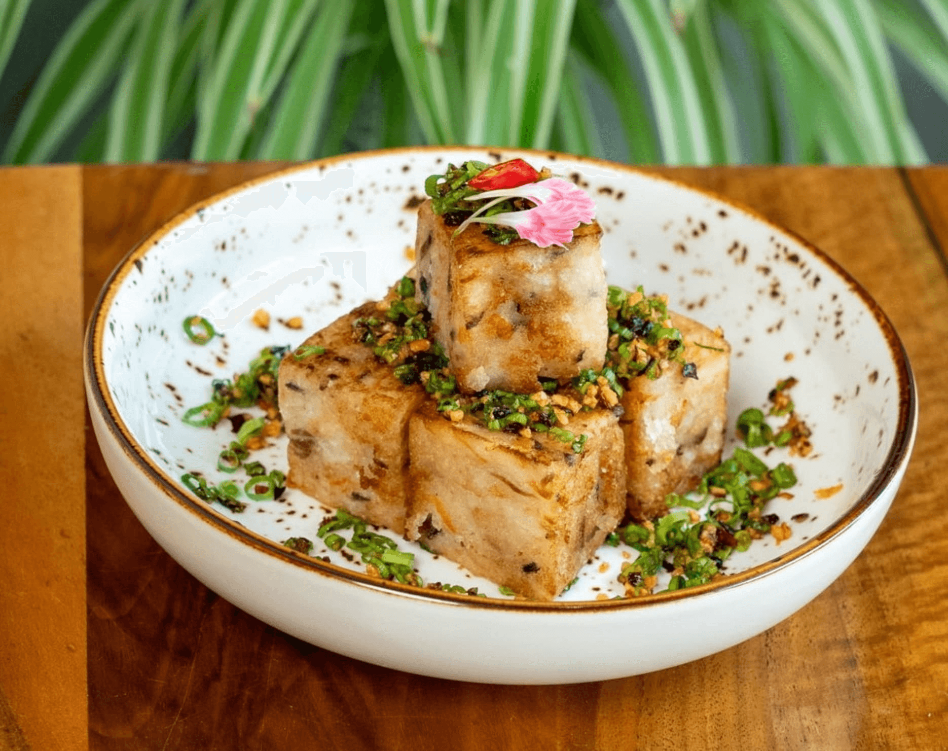 Vegetarian tofu cubes topped with herbs and spices on a plate.