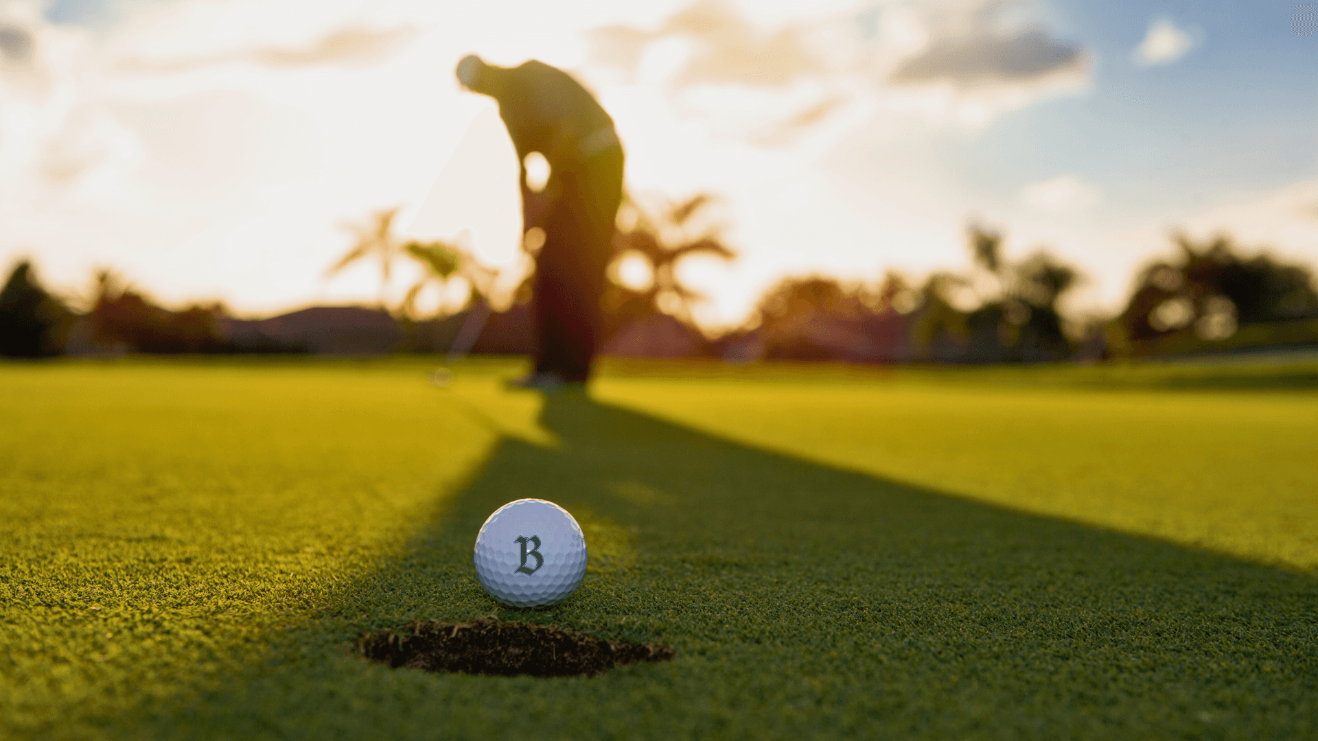 Portrait of three smiling people standing side by side against a neutral background — two men wearing black and grey t-shirts and a woman in a black zip-up hoodie.