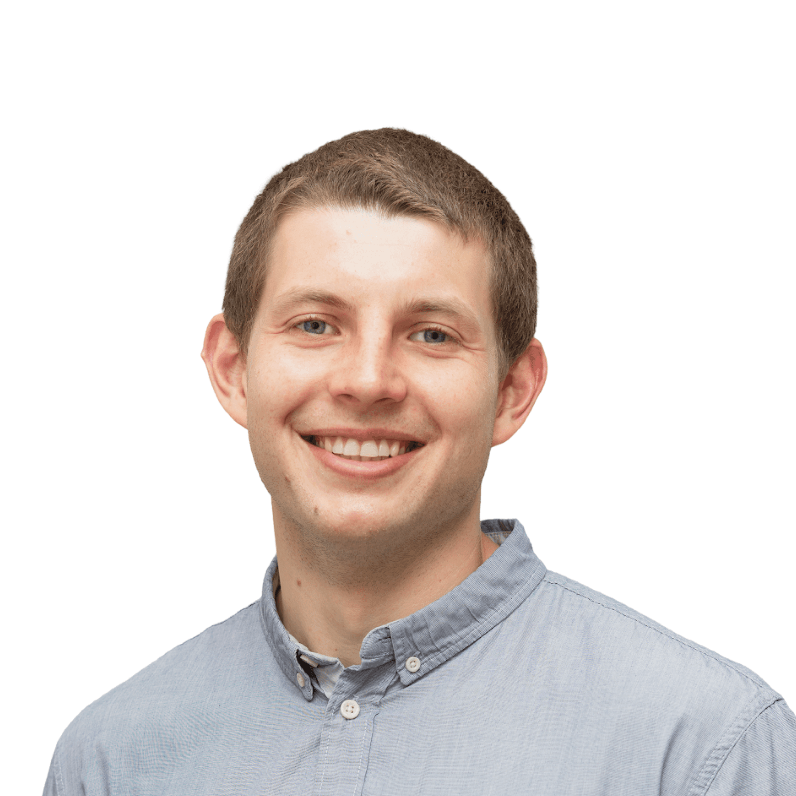 A man with dark hair and a blue shirt looks directly at the camera against a plain background.