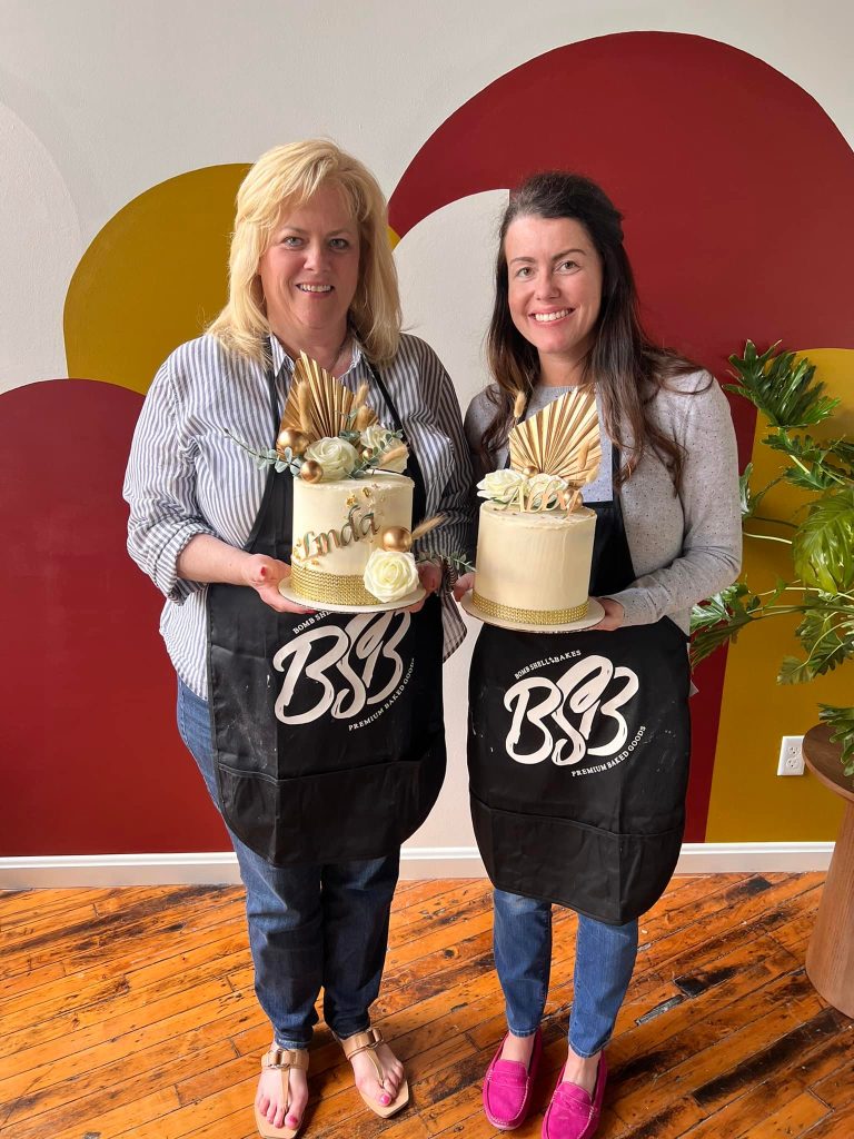 Bombshell Bakery founders holding decorated cakes