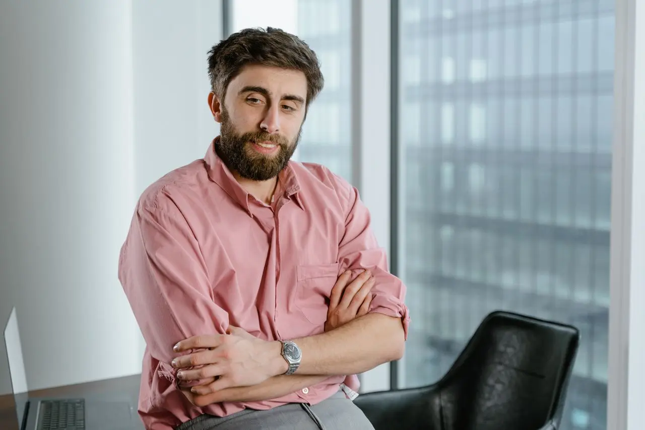 Imagem de um homem de negócios encostado em uma mesa do esritório