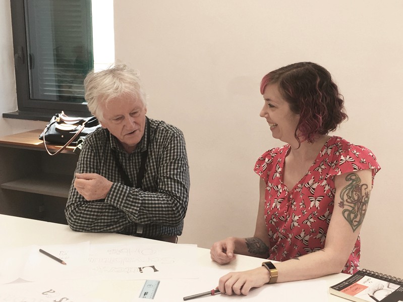 A photo of two people sitting at a table and talking.