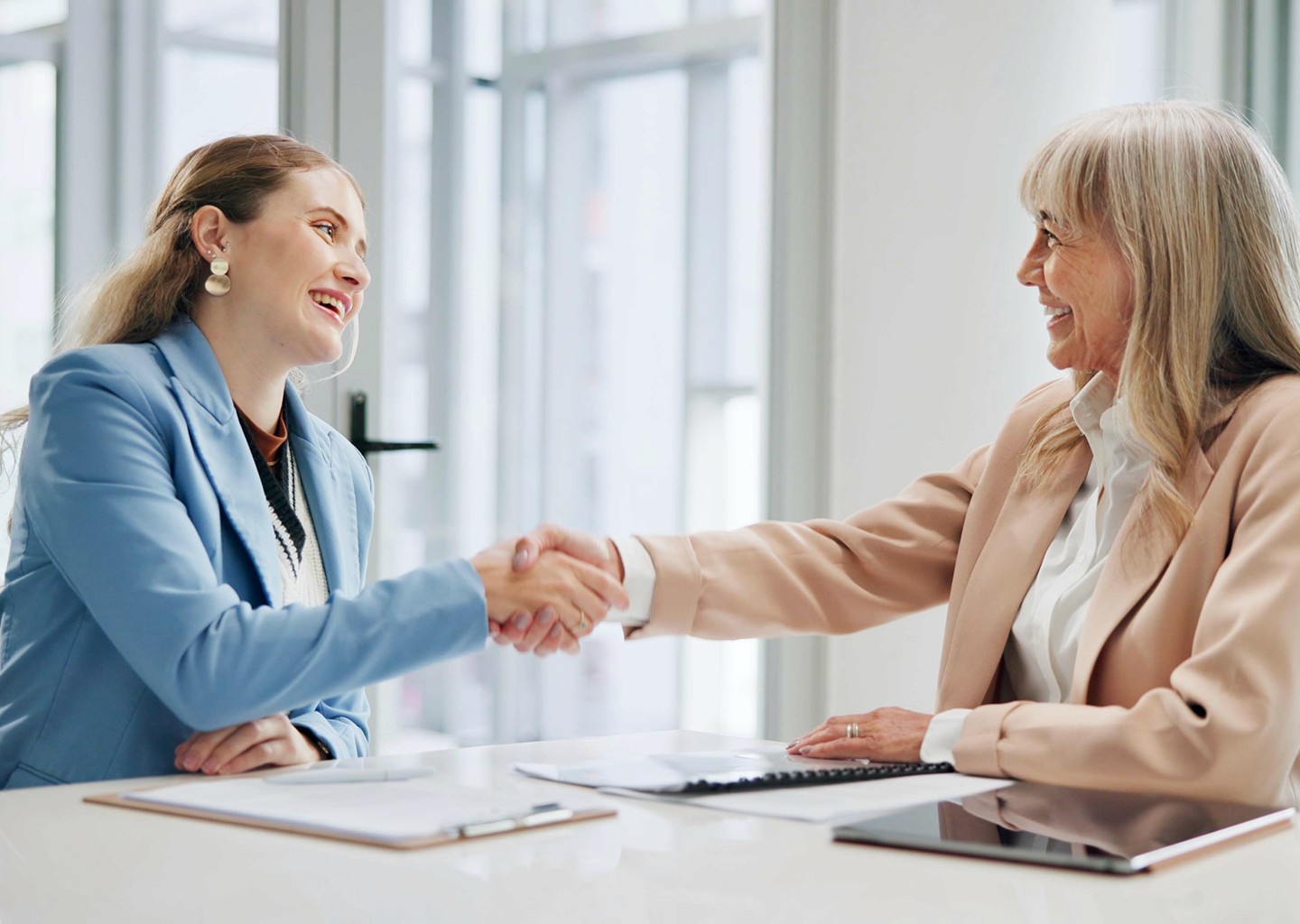 Donna accolta in ufficio da un responsabile HR, in un ambiente professionale e moderno, simbolo di inclusione lavorativa e bonus assunzioni 2025 per l’occupazione femminile.
