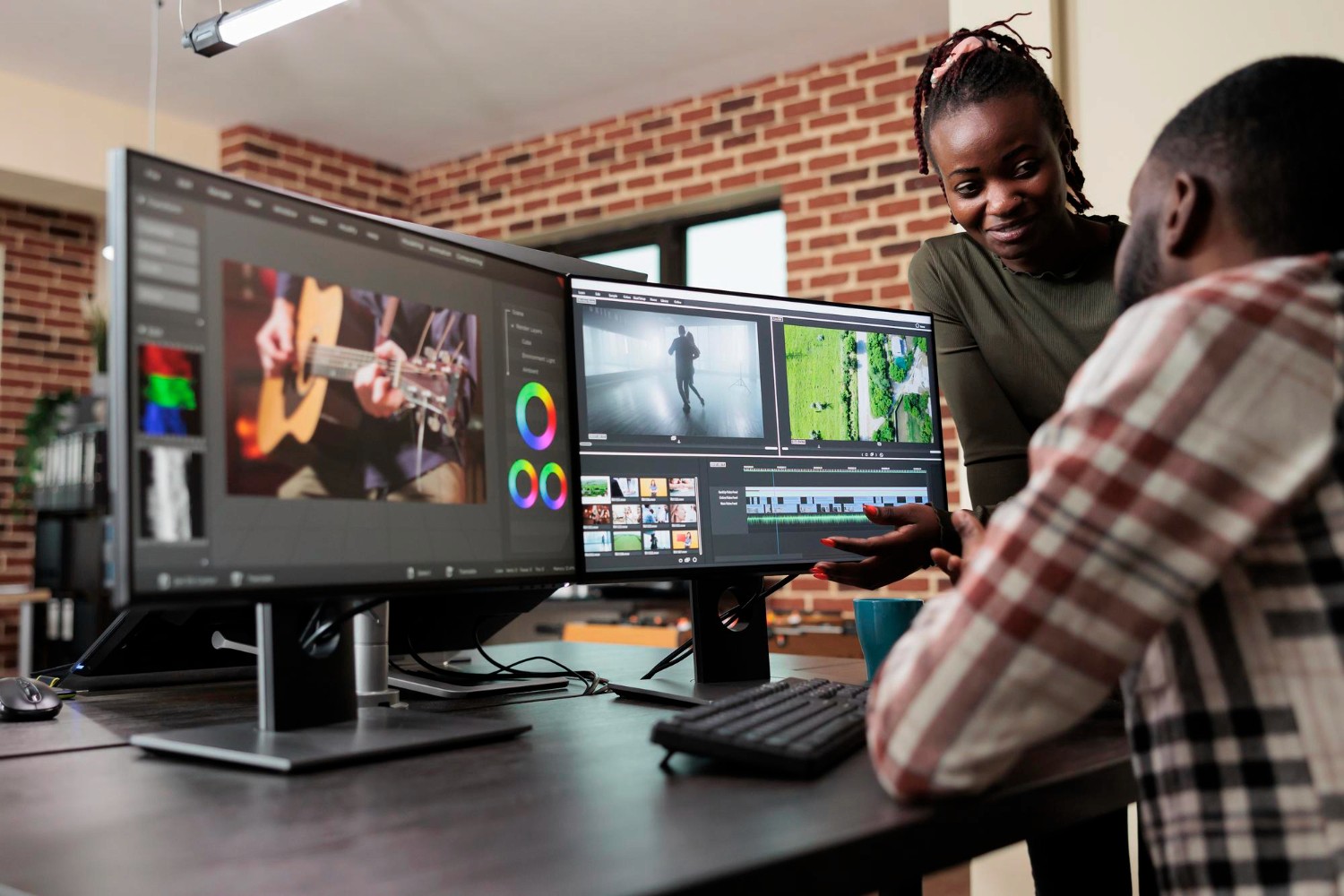 Employees working in a RAKEZ-licensed media production house, where a woman coaches a colleague in post-production and color grading.