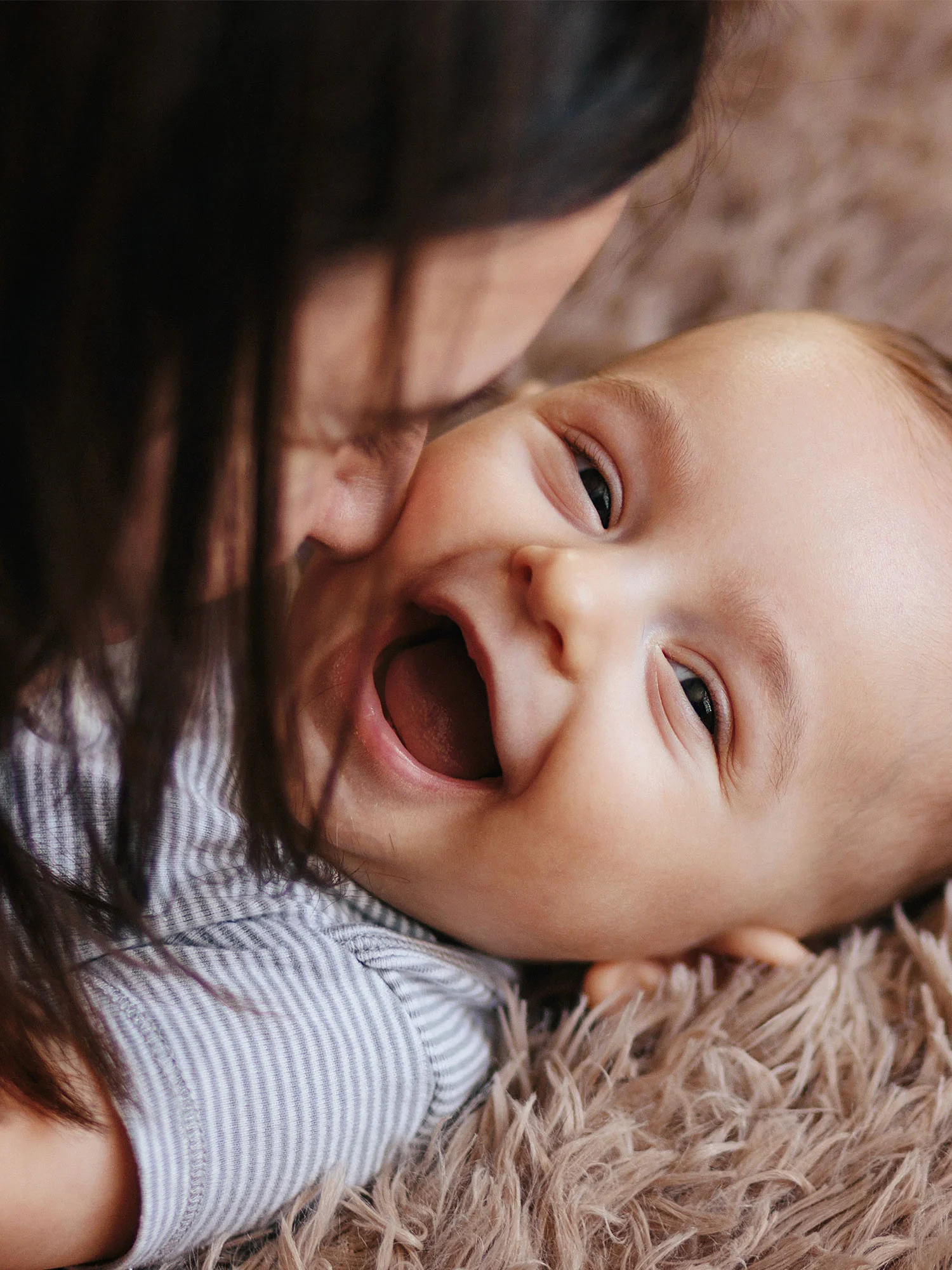 Smiling baby with parent representing caring, supportive, and patient-focused treatment experiences.