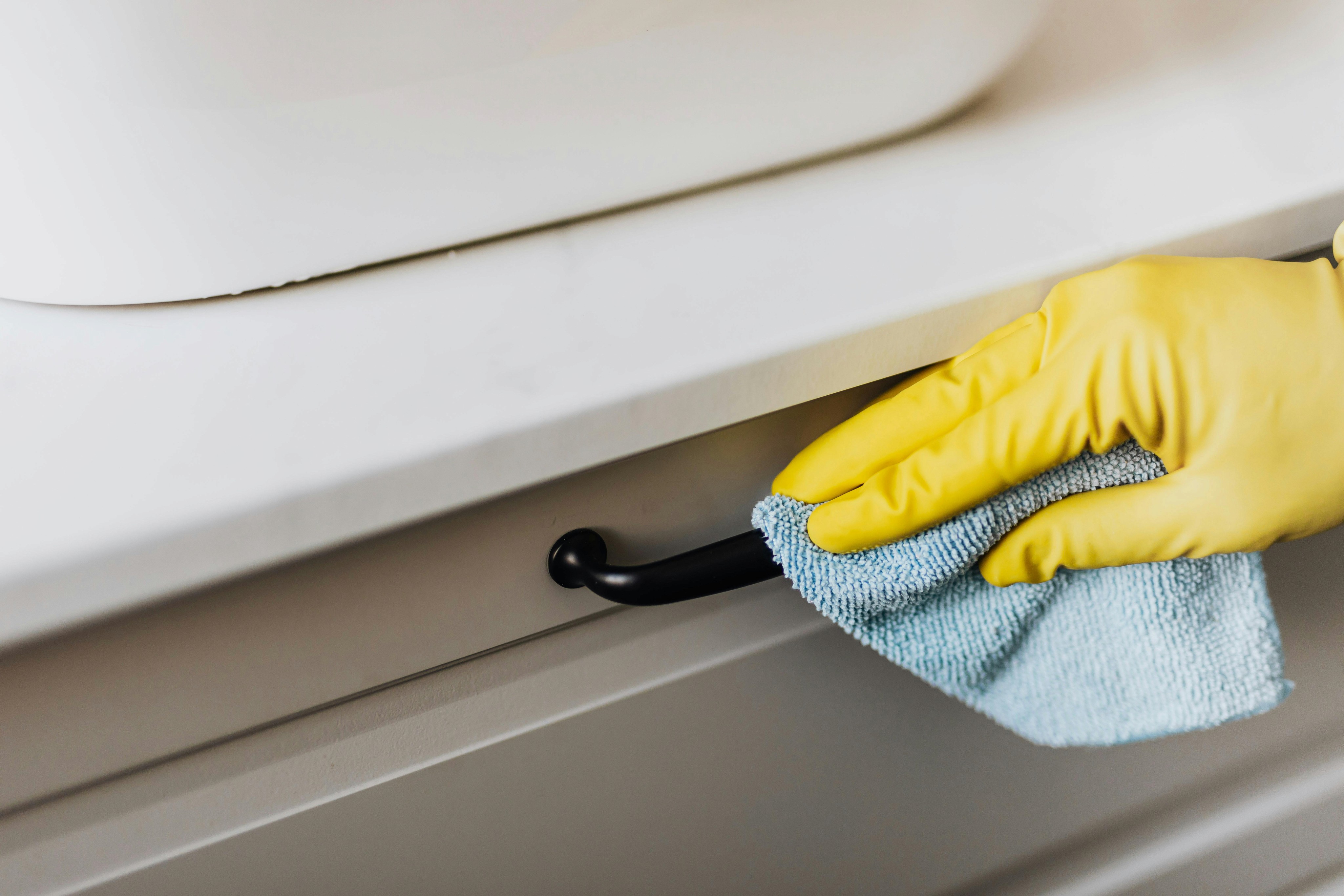 gently wiping down bathroom drawer handle