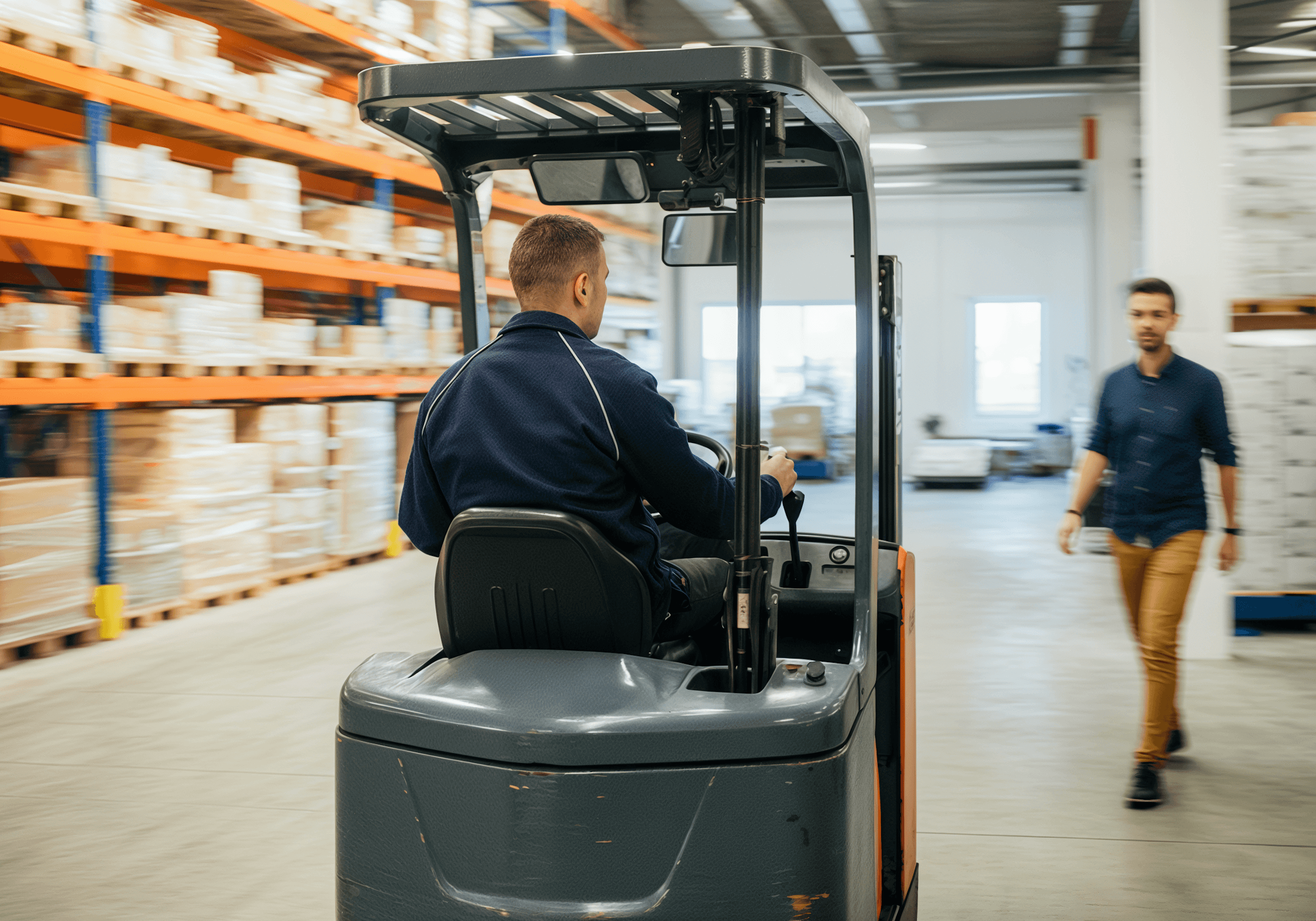 Confident man with short brown hair and beard, wearing a navy zip-up in natural light