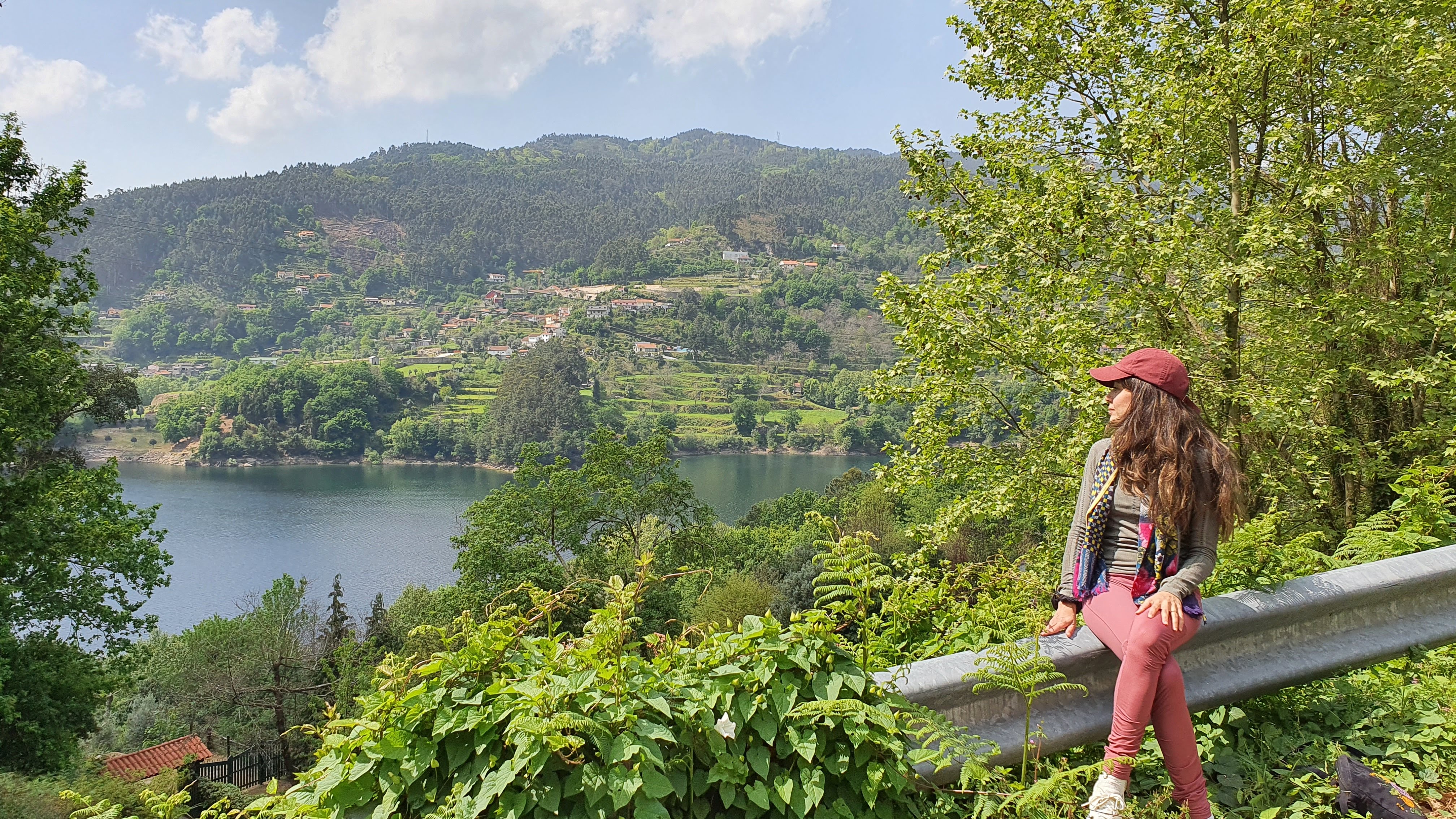 Samira standing at edge of cliff looking at clouds
