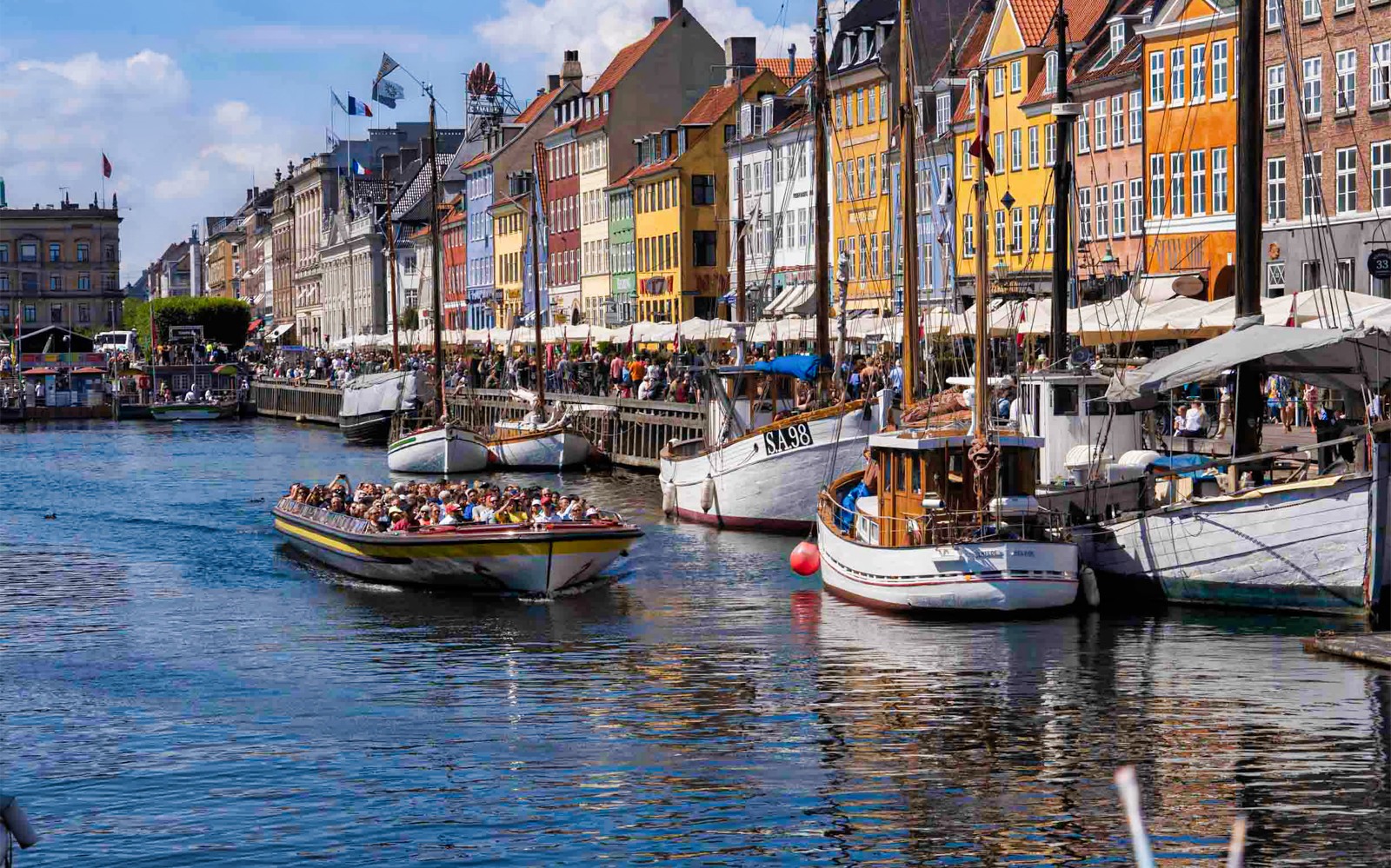 Hajókirándulás a színes épületek mentén a koppenhágai Nyhavn csatornán.