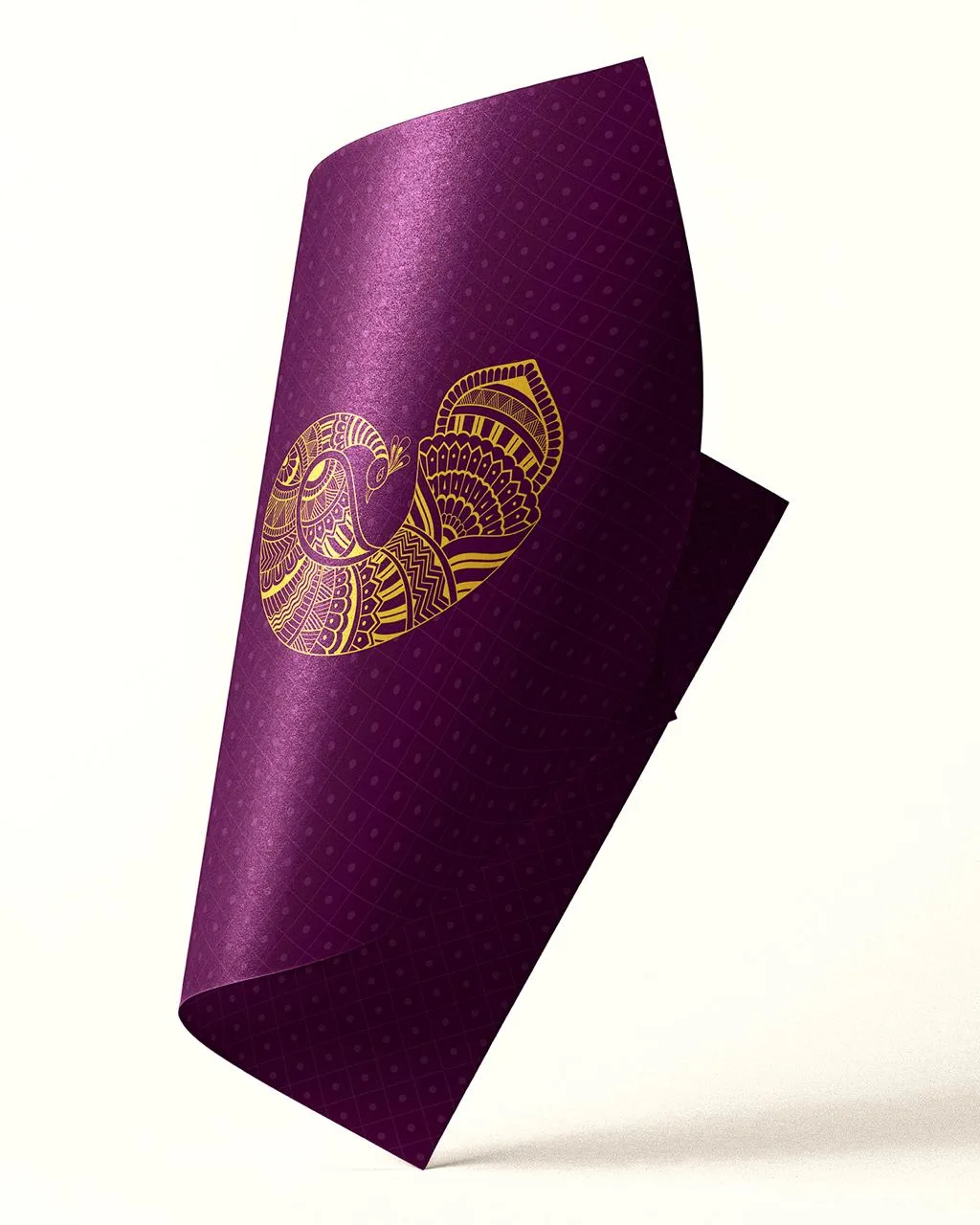 Deep-purple textured card with a gold paisley and floral motif, folded at an angle against a white background, creating an elegant, festive mood.