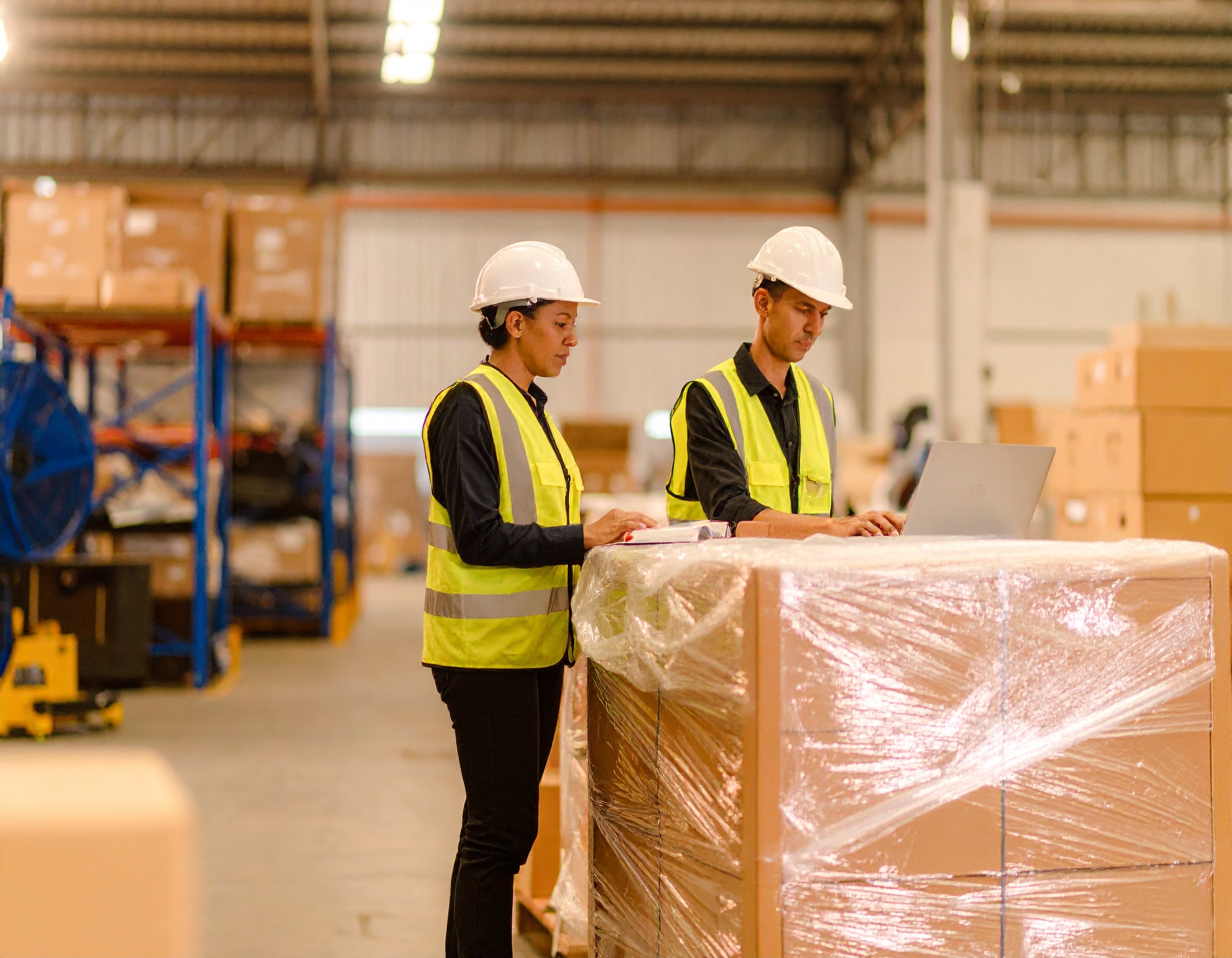 technicians discussing over shrink wrapped boxes