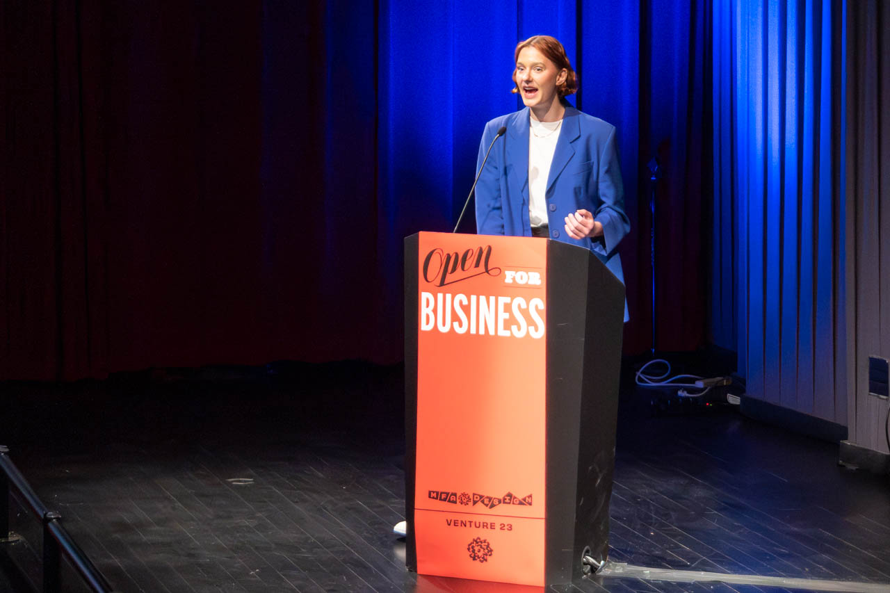 woman standing at a podium delivering a presentation