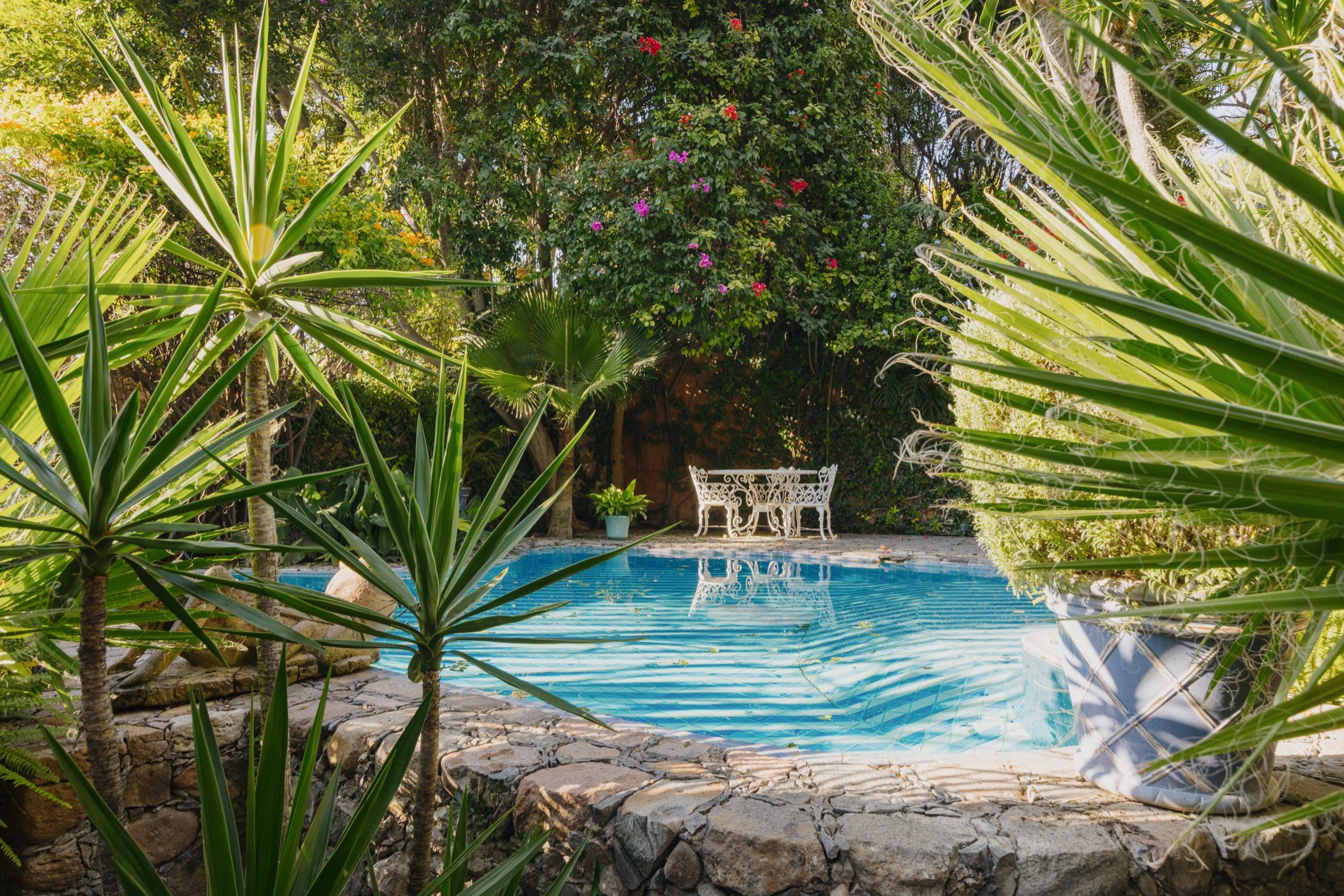 La Residencia San Miguel sculpted garden hedges with pool and stone sculptures beyond