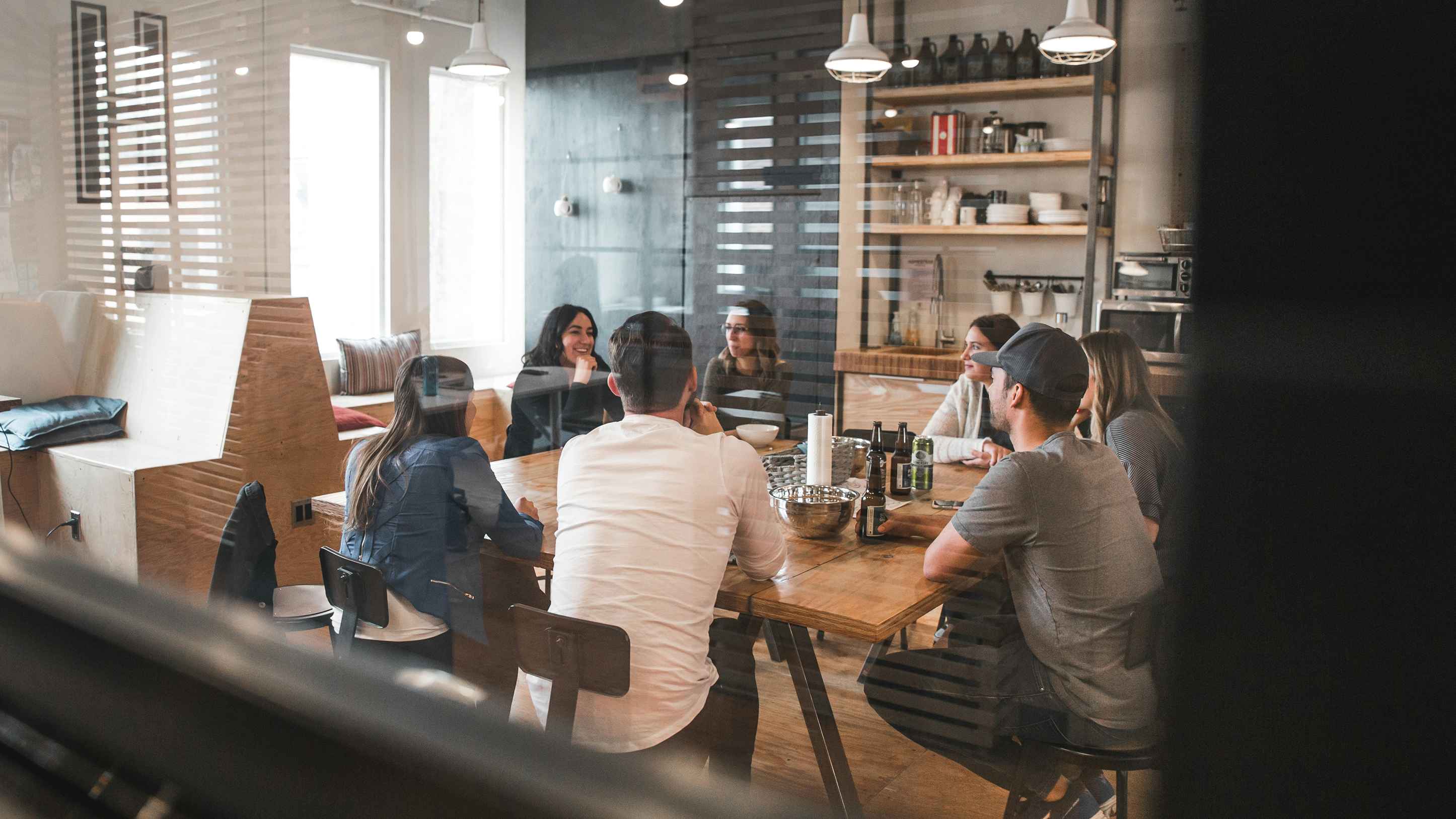 A team gathering around a window table in a office kitchen