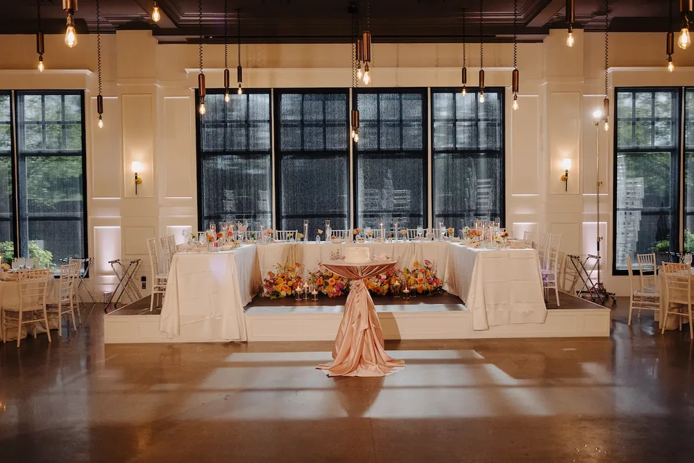 A beautifully set dining table with white tablecloth, cutlery, and fresh greenery in a cozy, well-lit space.