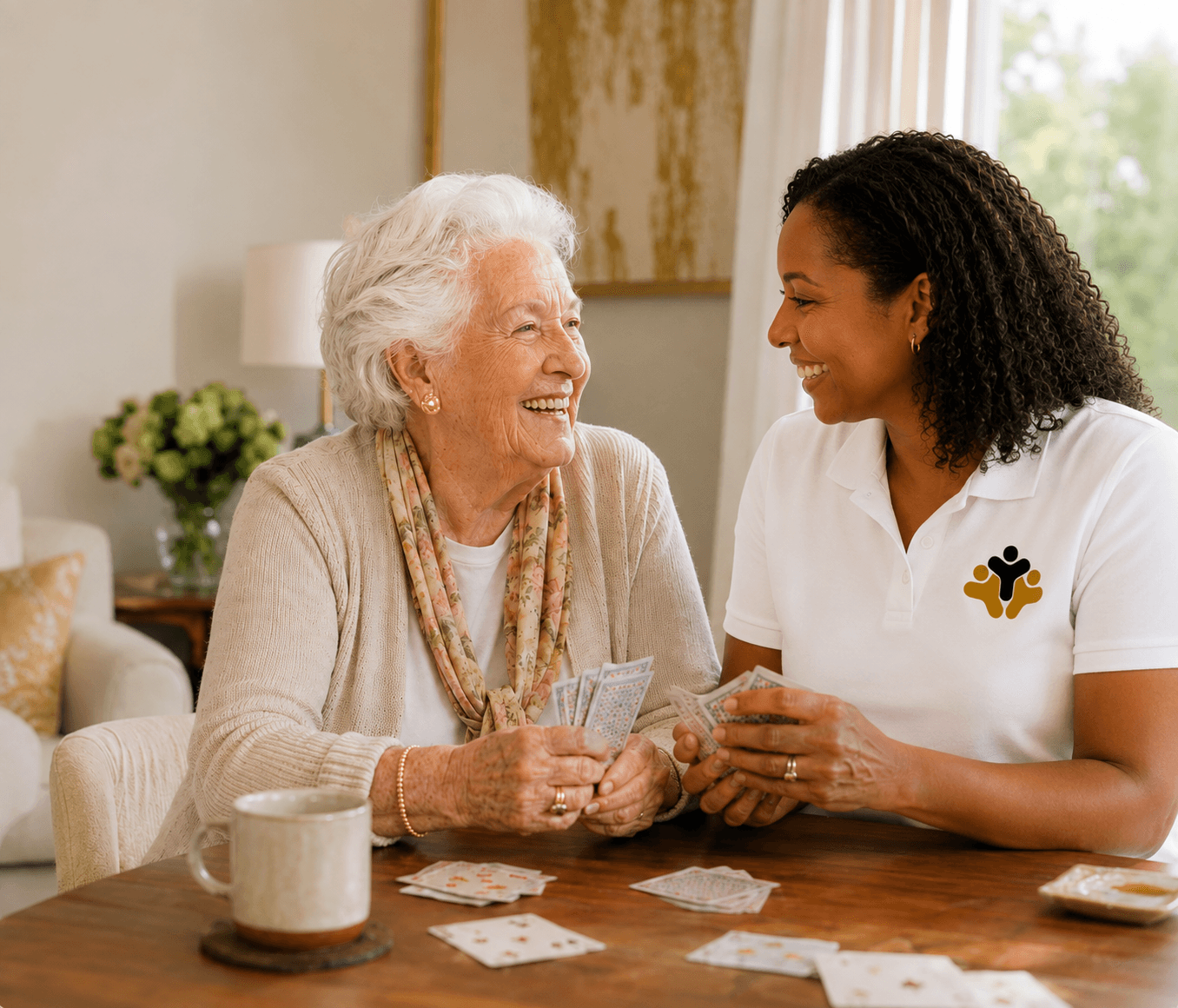 A senior woman laughing with her uniformed caregiver in a warm, supportive care setting