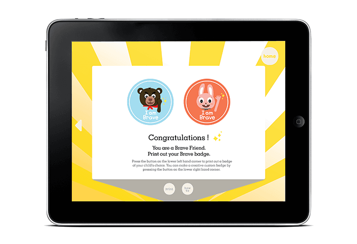A tablet displays a congratulatory message: “Congratulations! You are a Brave Friend. Print out your left hand corner to print out a badge of your child’s choice. You can make a custom badge by pressing the button on the lower right band corner.” Two circular icons, one blue and one red, show a bear and a rabbit respectively, with the text “I am Brave” beneath each. The tablet’s home button is visible in the top right corner.