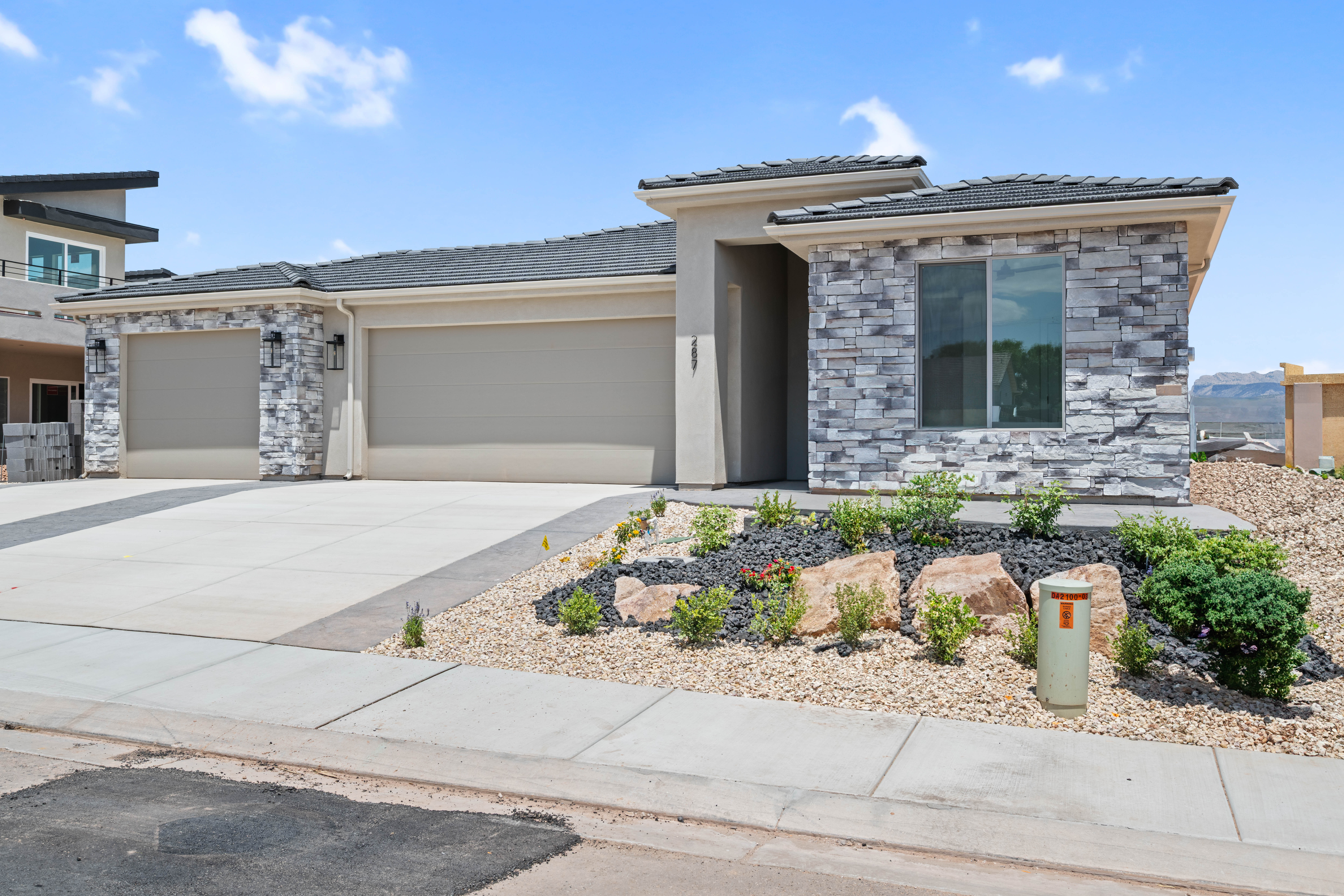 Front exterior of The Nest at Falcon Ridge, a custom home in Hurricane, Utah, showing entryway, landscaping, and architectural details.