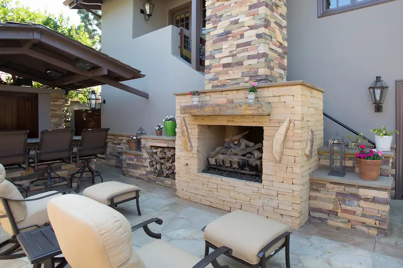Outdoor patio fireplace with stone veneer and matching furniture. From the Big Canyon Remodel project. Photo by Chris Darnall.