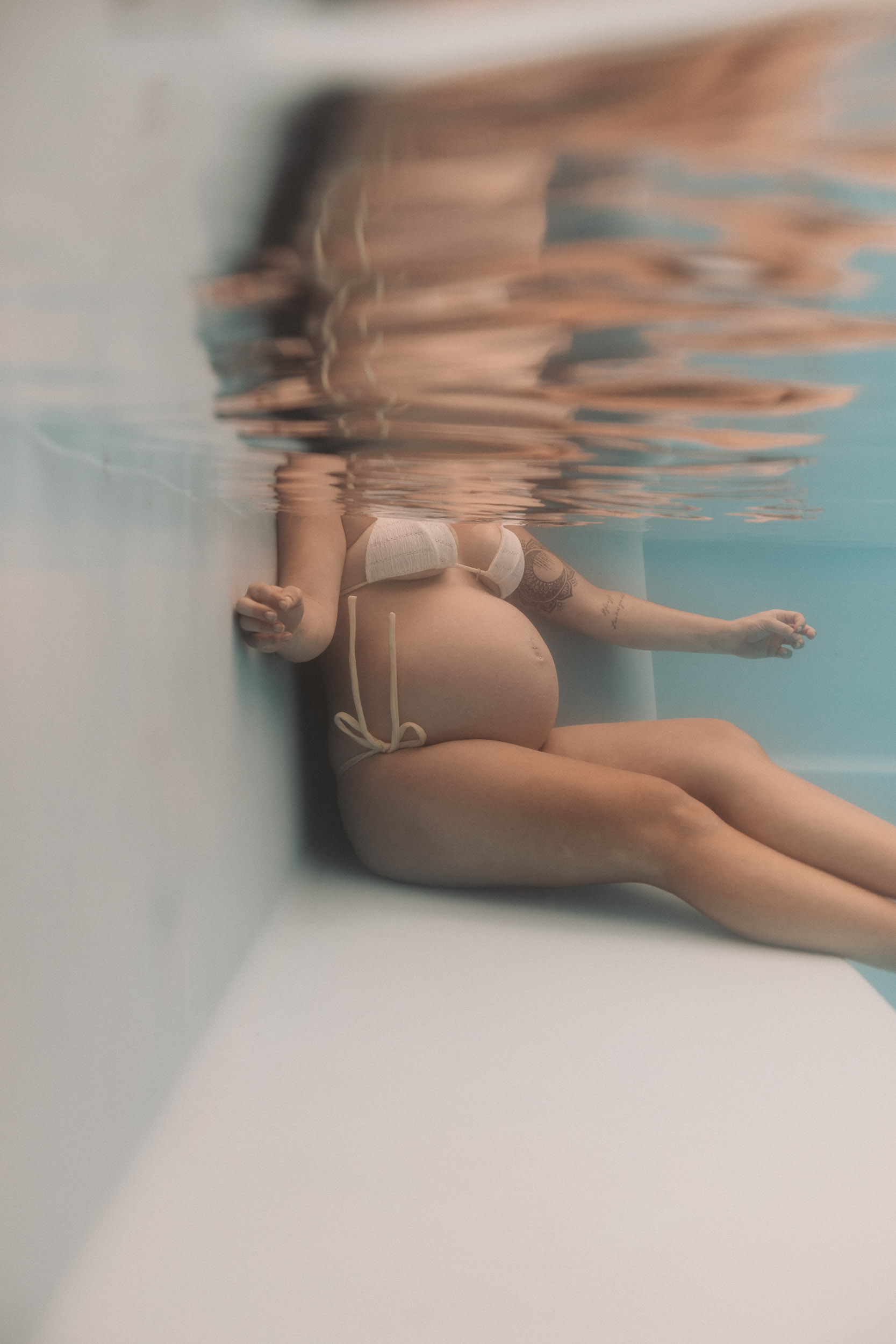 Fine art pool maternity session in Mackay capturing a pregnant woman underwater