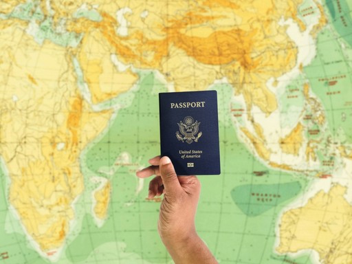 a hand holding a passport over a map illustrating the remote work from France