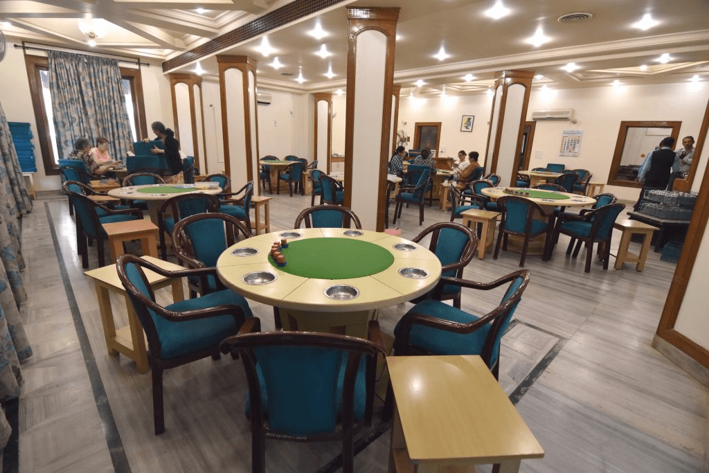 Inside view of a casino room with several poker tables and chairs, featuring a serene and elegant atmosphere.