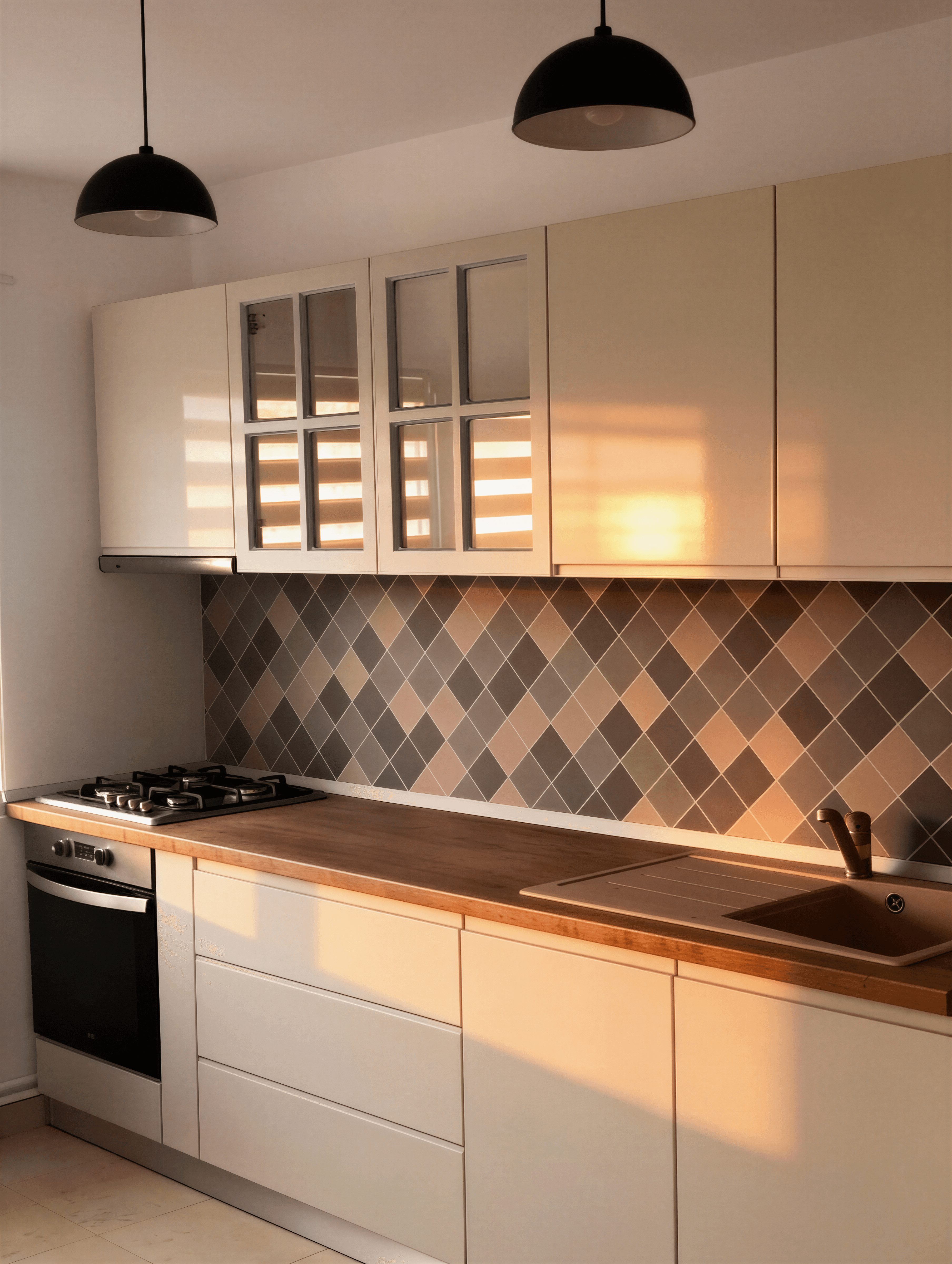 Bucătărie modernă cu dulapuri albe, blaturi din lemn și placare model diamant.