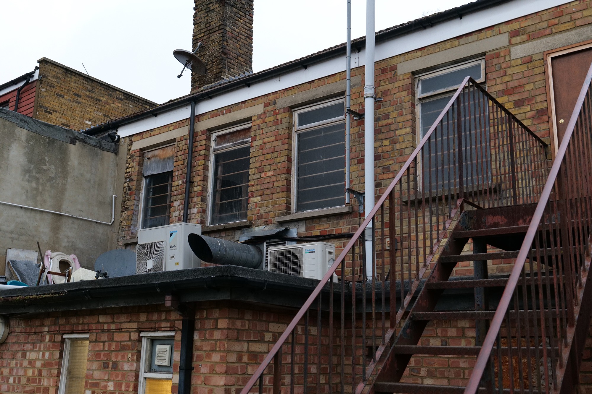 Barry Turner and Son inspecting run down apartment which shows significant draught and window damage.
