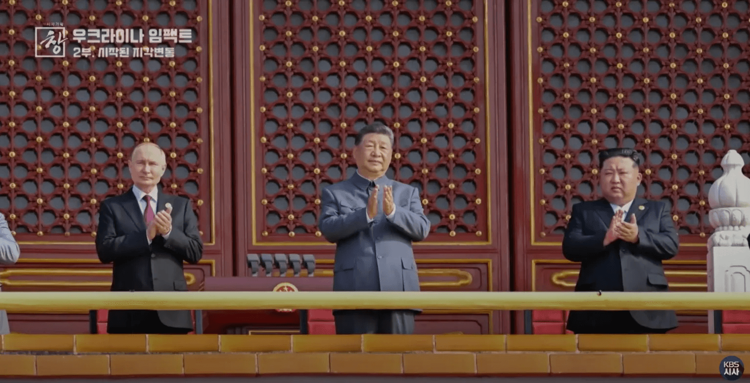 2025년 9월 3일 중국 전승절 열병식에서 푸틴 러시아 대통령, 시진핑 중국 국가주석, 김정은 북한 국무위원장이 나란히 서서 박수를 치고 있다. 천안문 광장의 붉은 전통 건축물을 배경으로 세 정상이 한자리에 모인 모습은 66년 만의 일로, 북중러 삼각연대 강화를 상징적으로 보여준다.