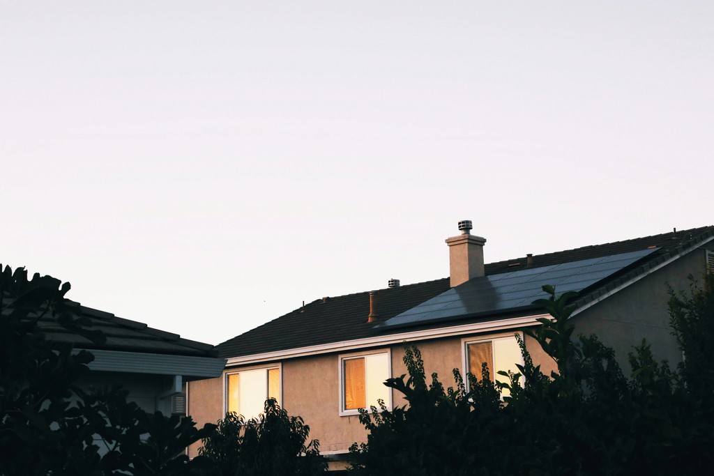brown and white concrete house with solar panels