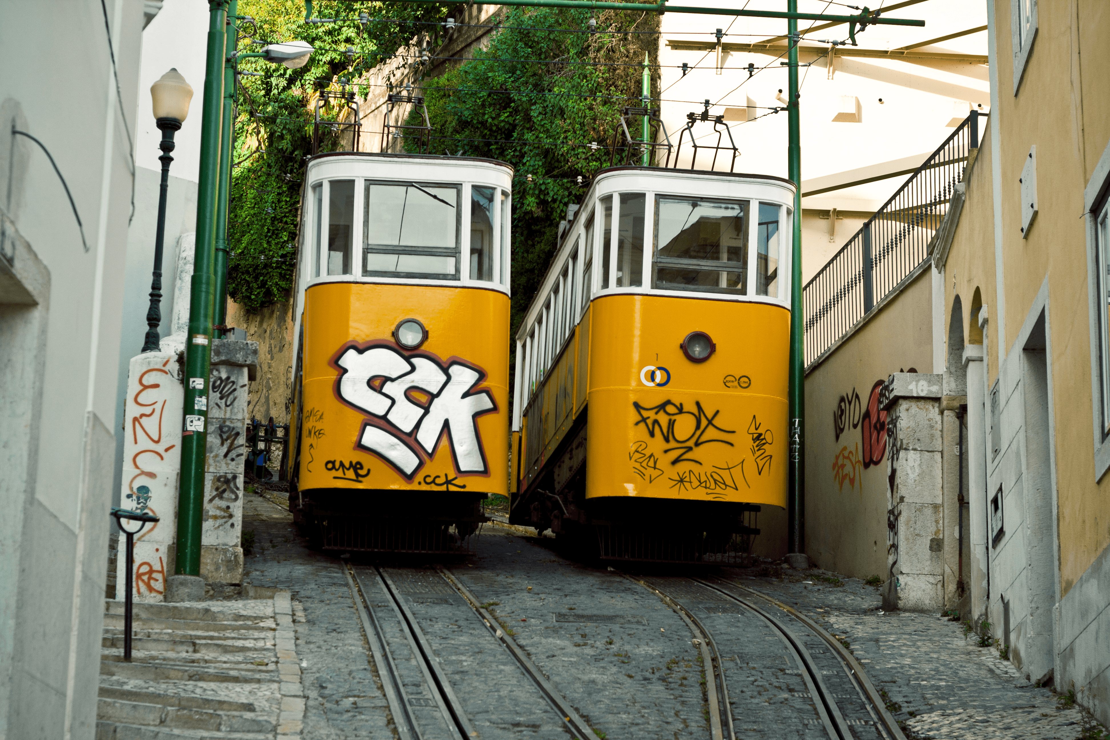 Two yellow Ascensor do Lavra funicular cars on the steep track in Lisbon