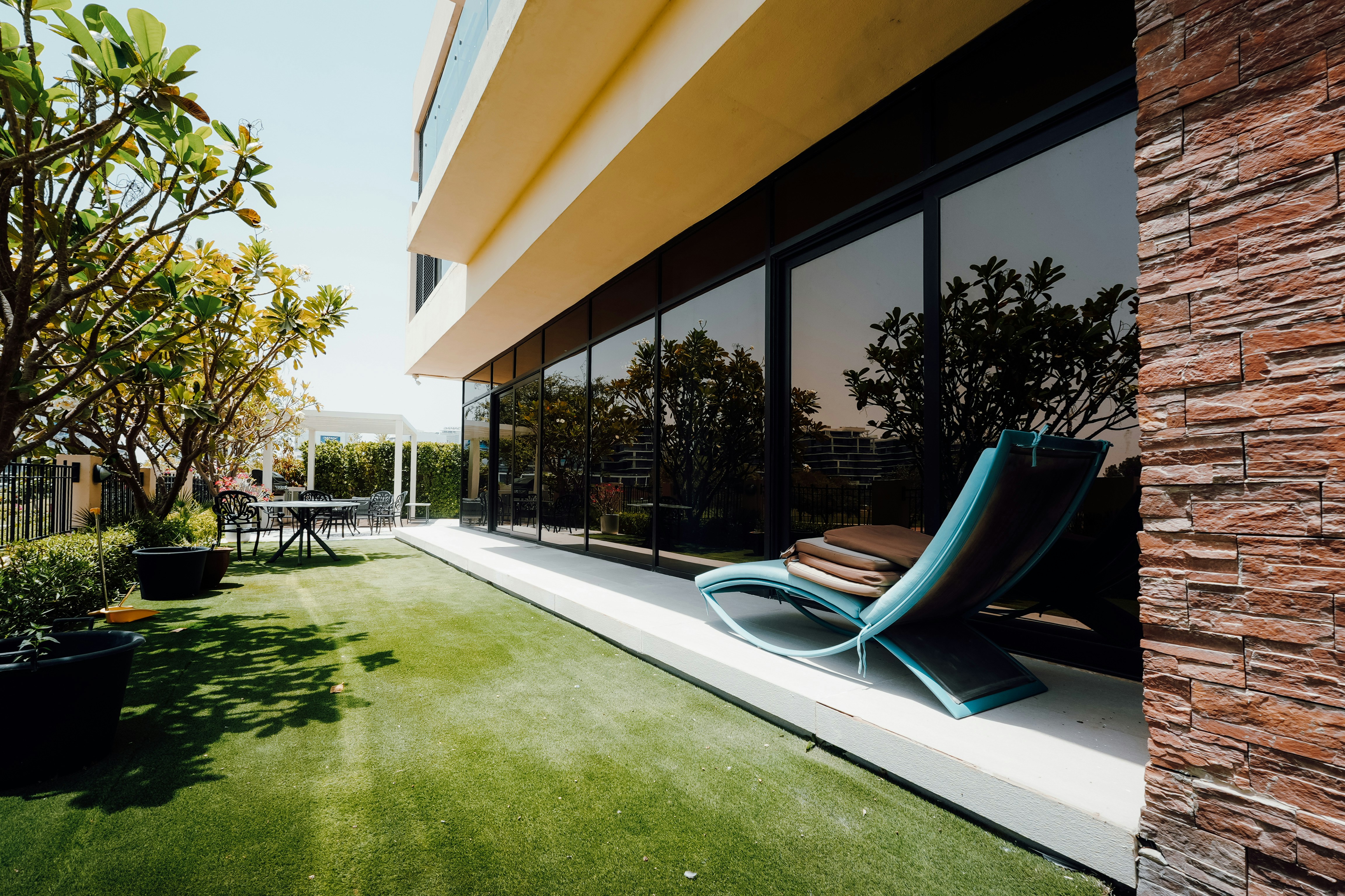 Modern balcony with lounge chair and artificial grass.