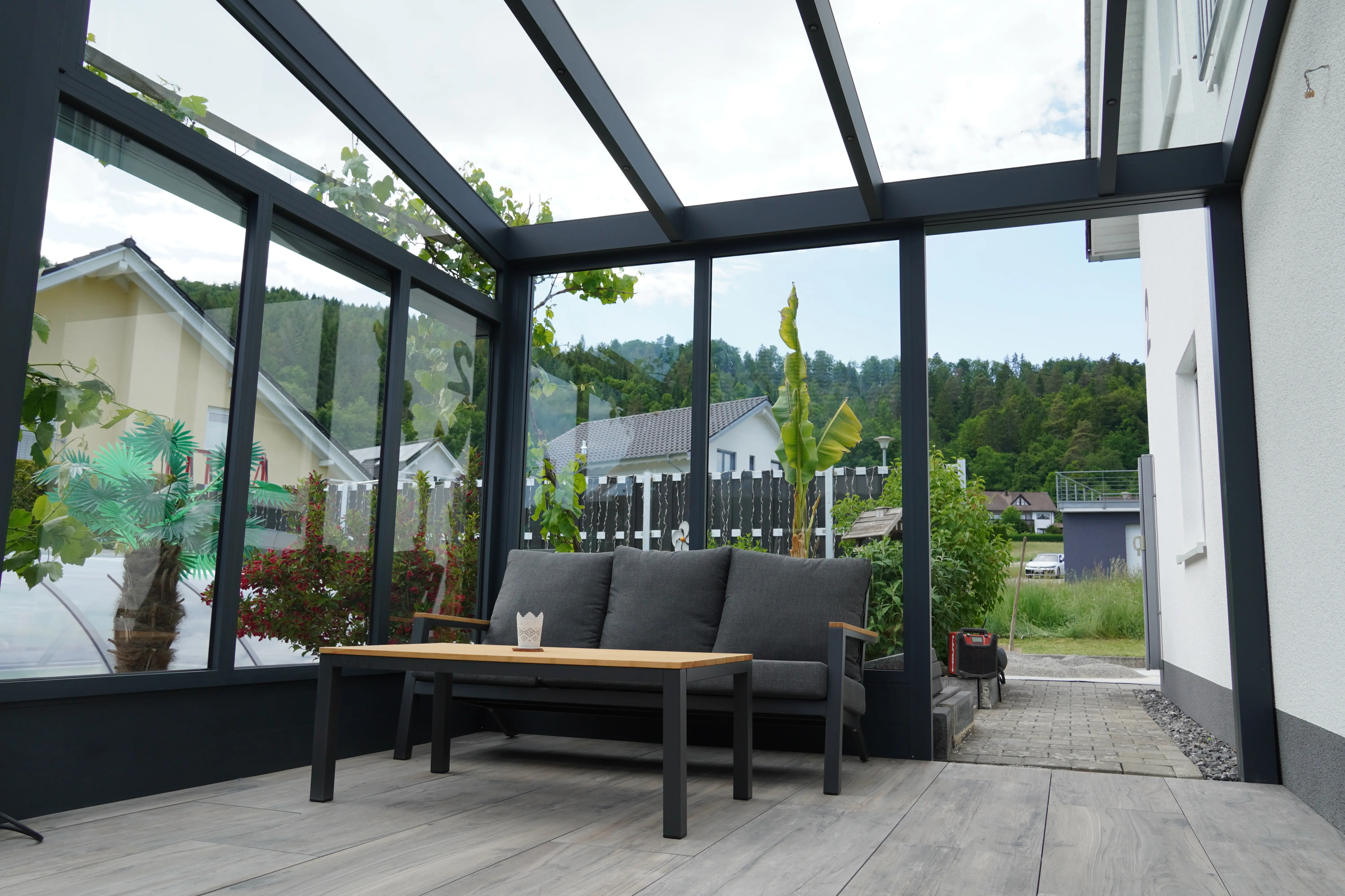 Verglaster Kaltwintergarten mit Glasdach und gemütlichem Loungebereich