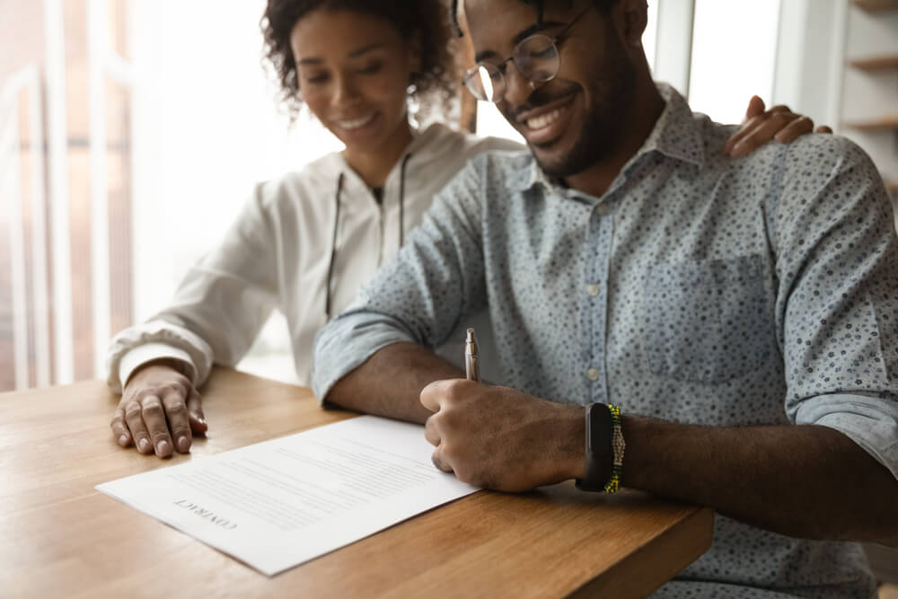 Couple signing paper together