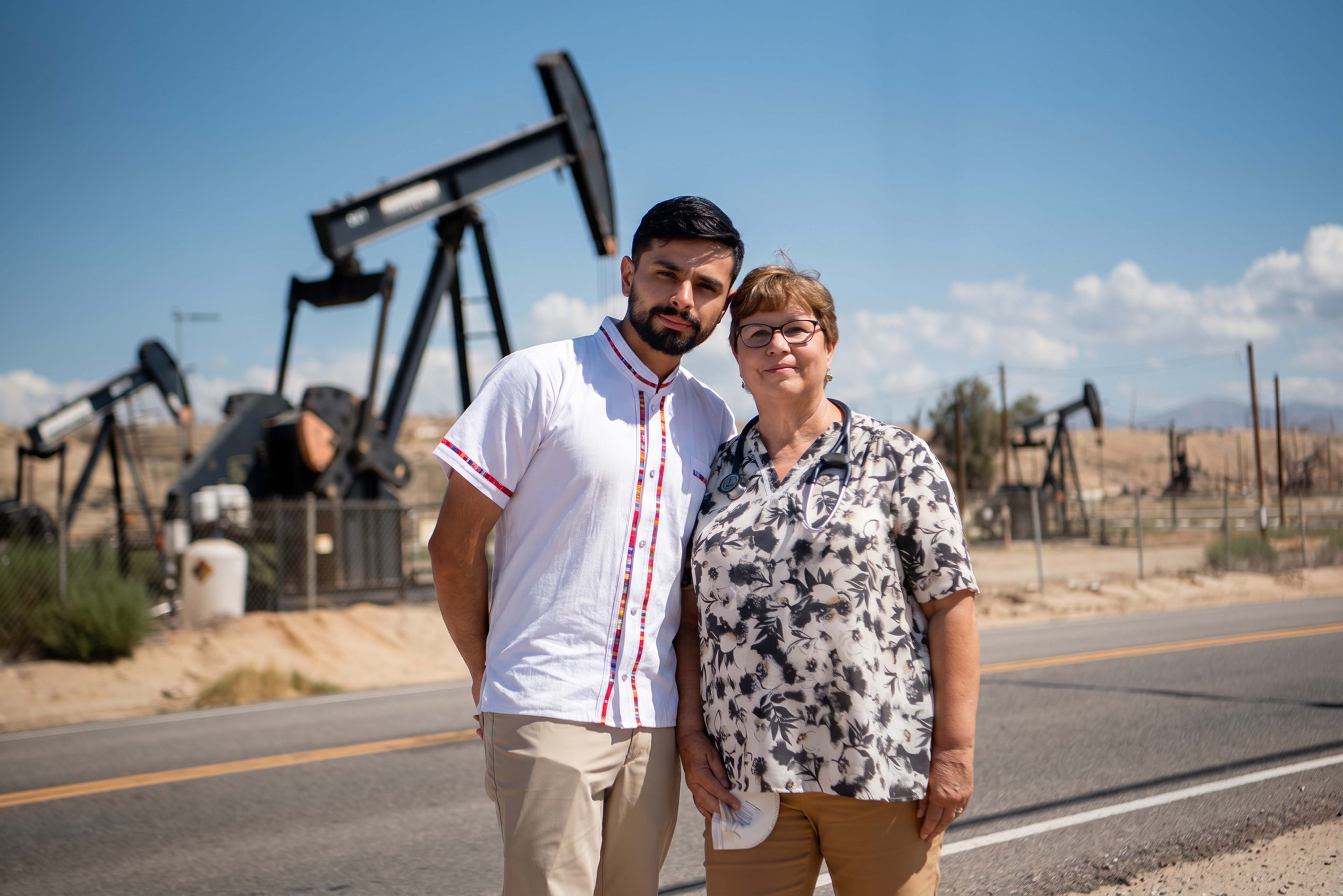 A mother and child in front of oil rigs in California.