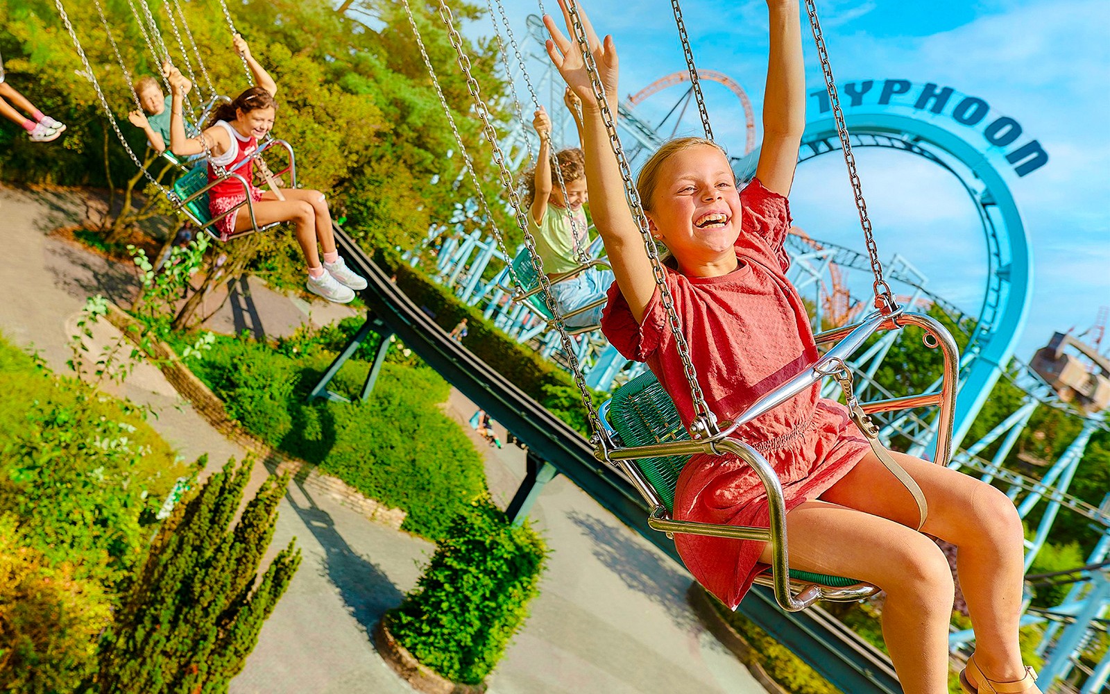 Kids enjoying swing ride at Bobbejaanland theme park.