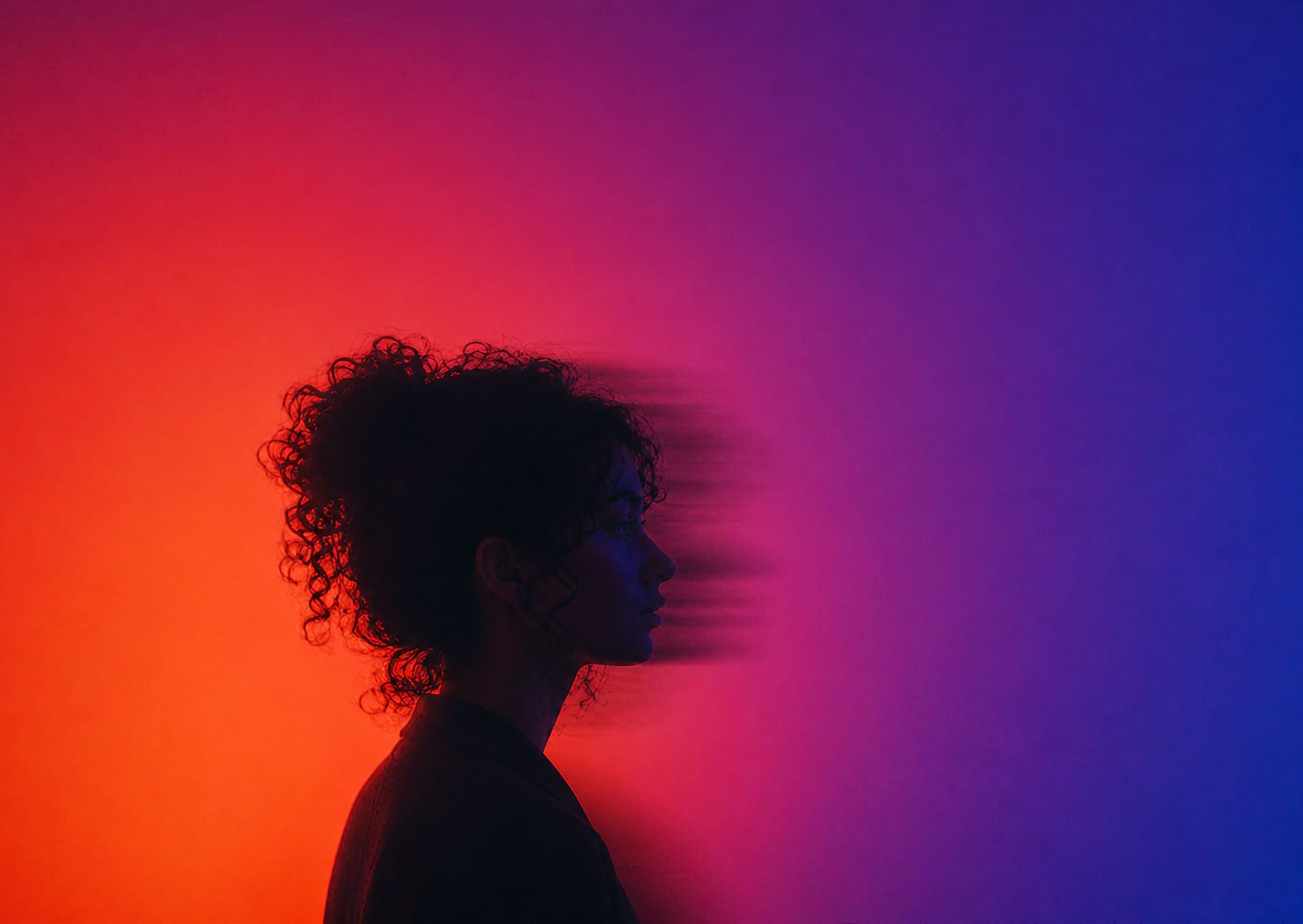 Portrait in profile lit by red and blue gradient light