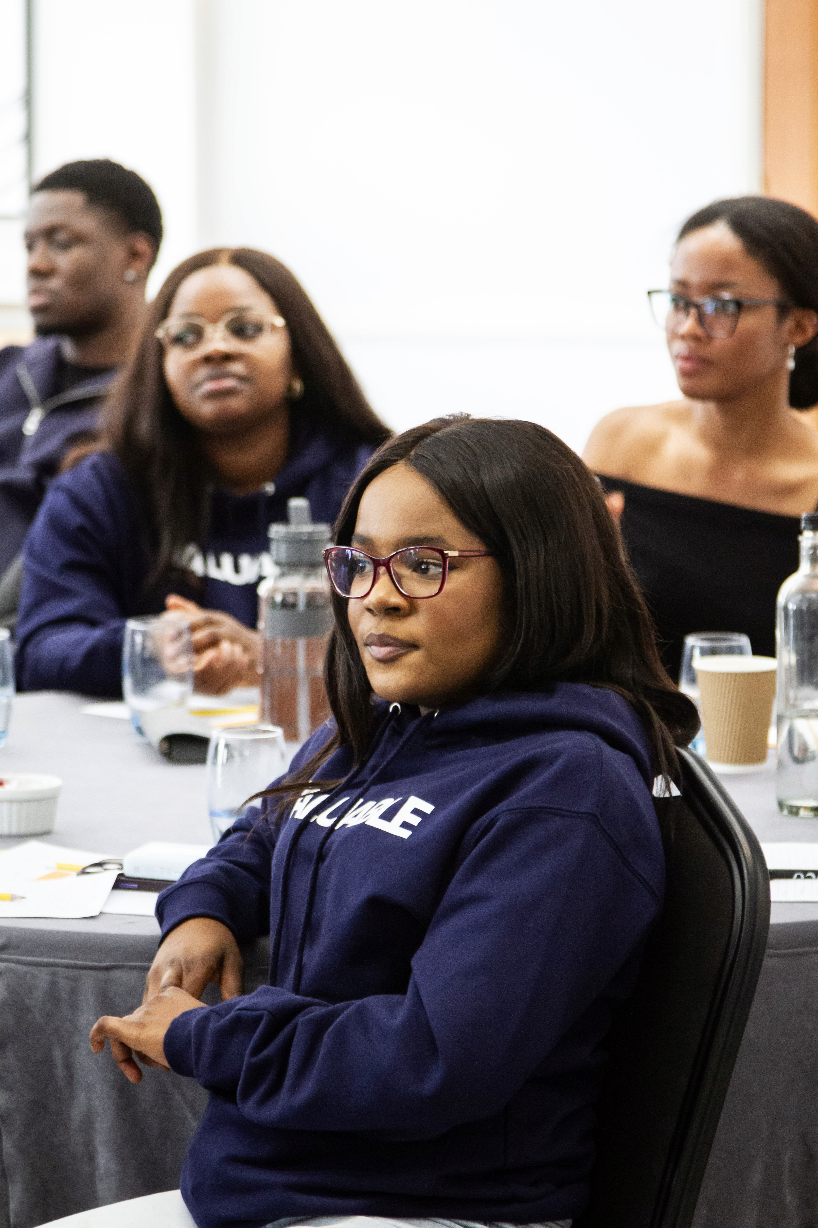 Women sitting down focusing attentively on speaker in conference room. 