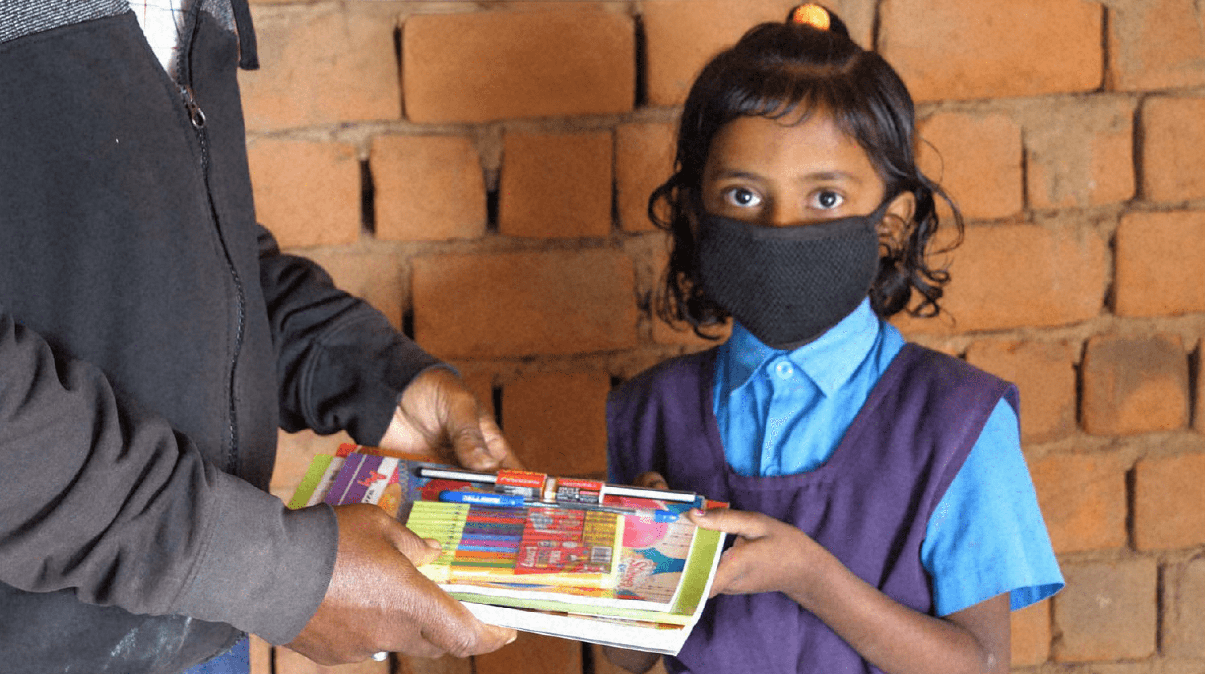 Child receiving educational supplies, highlighting impact of learning support initiatives