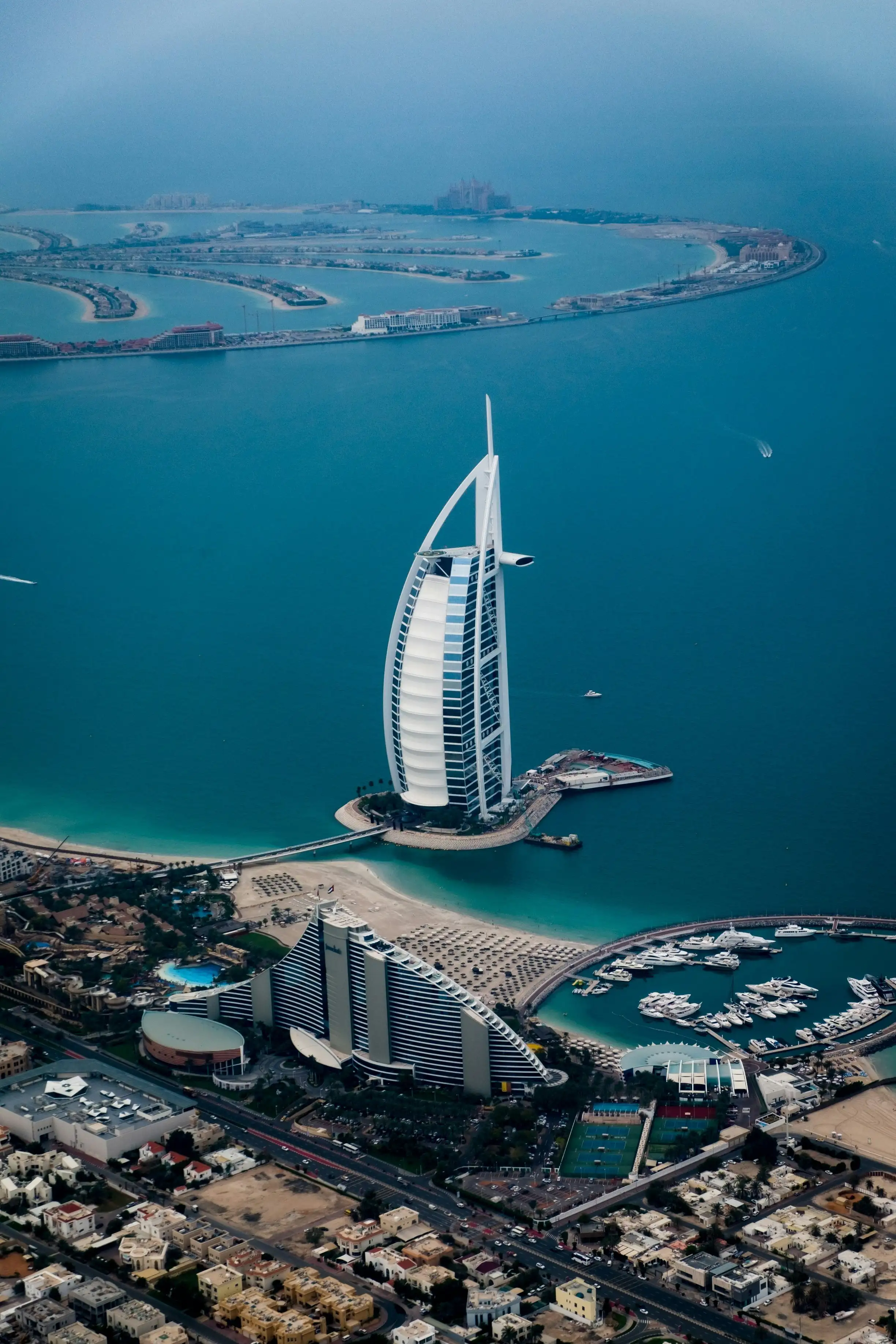 Vista aérea del Burj Al Arab y la costa de Dubái con playas y puerto deportivo