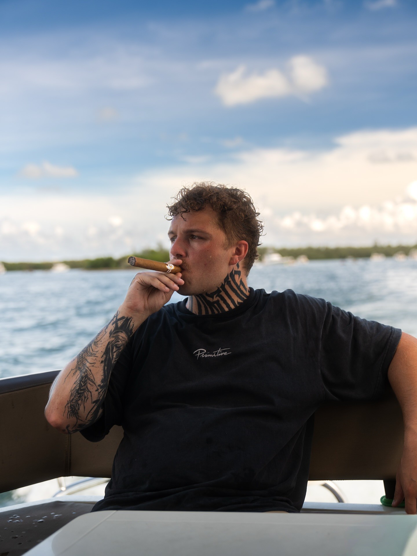 man in white crew neck t-shirt and black pants sitting on rock during daytime