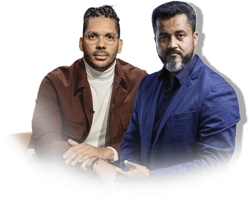 Headshots of  two men sitting side by side. The man on the left has brown skin and is wearing a maroon jacket. The man on the right has brown skin and is wearing a blue suit jacket.